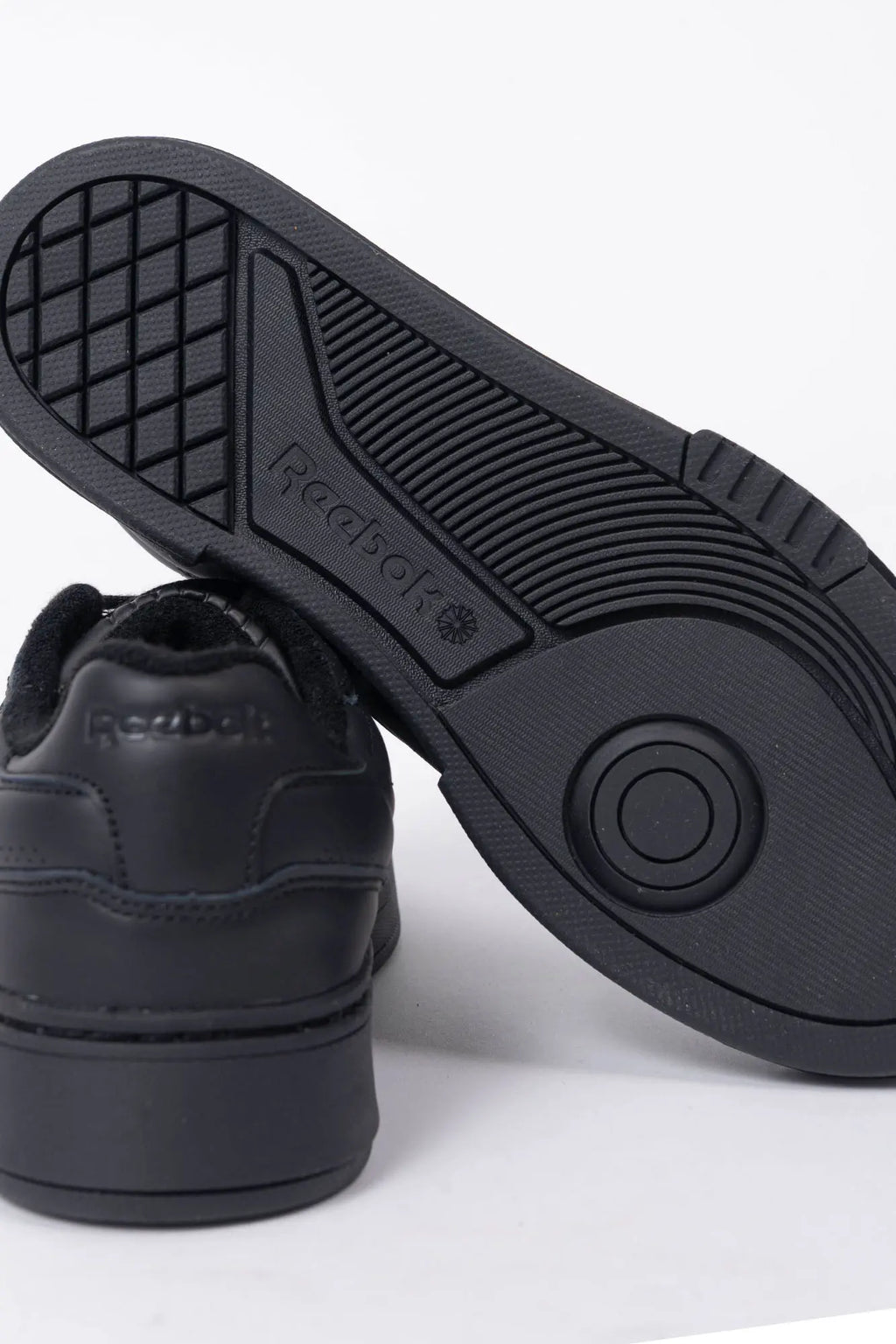 Reebok, Mens Sneakers, Black, Full Leather, Low-Cut Design, Rubber Outsole, Cushioned EVA Midsole, Reebok Club C LTD SS26, Leather U.K. Details, Wimbledon Sneaker, Tennis Court, Grass, Racket, Wilson, Head, Outsole and Back Close-up View. 