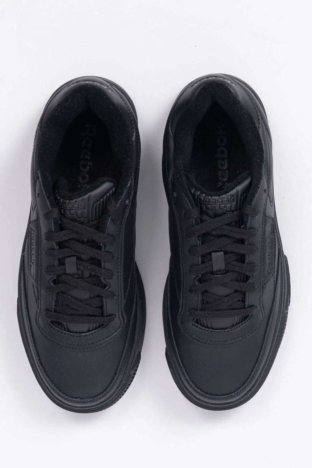 Reebok, Mens Sneakers, Black, Full Leather, Low-Cut Design, Rubber Outsole, Cushioned EVA Midsole, Reebok Club C LTD SS26, Leather U.K. Details, Wimbledon Sneaker, Tennis Court, Grass, Racket, Wilson, Head, Top-Down View. 