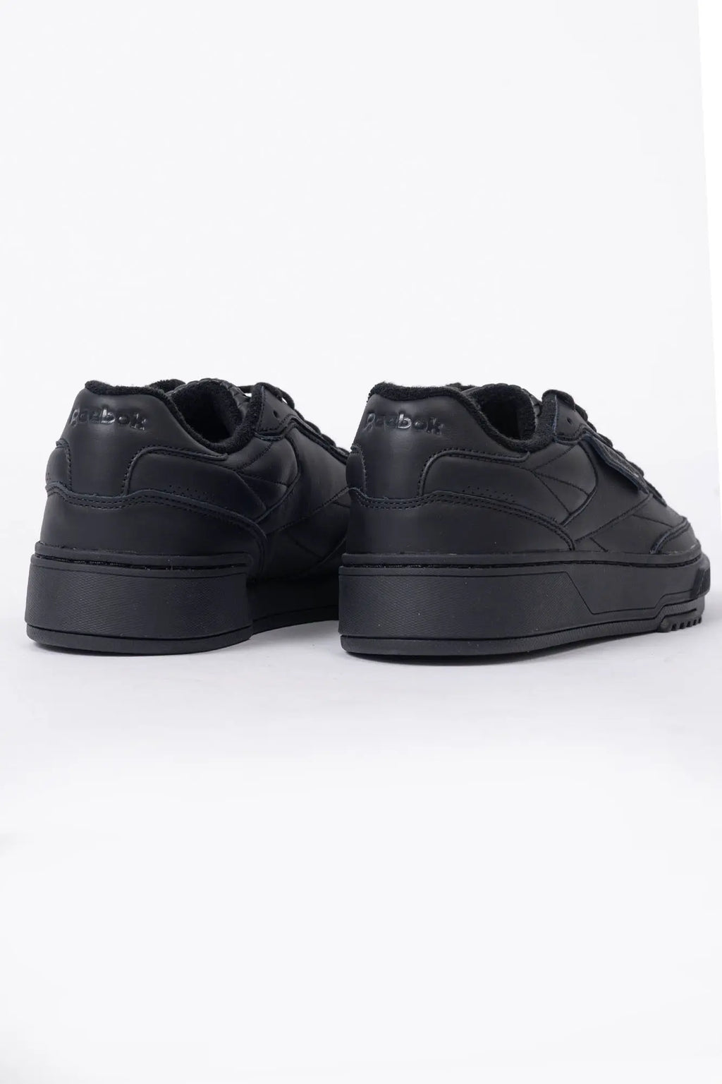 Reebok, Mens Sneakers, Black, Full Leather, Low-Cut Design, Rubber Outsole, Cushioned EVA Midsole, Reebok Club C LTD SS26, Leather U.K. Details, Wimbledon Sneaker, Tennis Court, Grass, Racket, Wilson, Head, Back 3/4 View. 