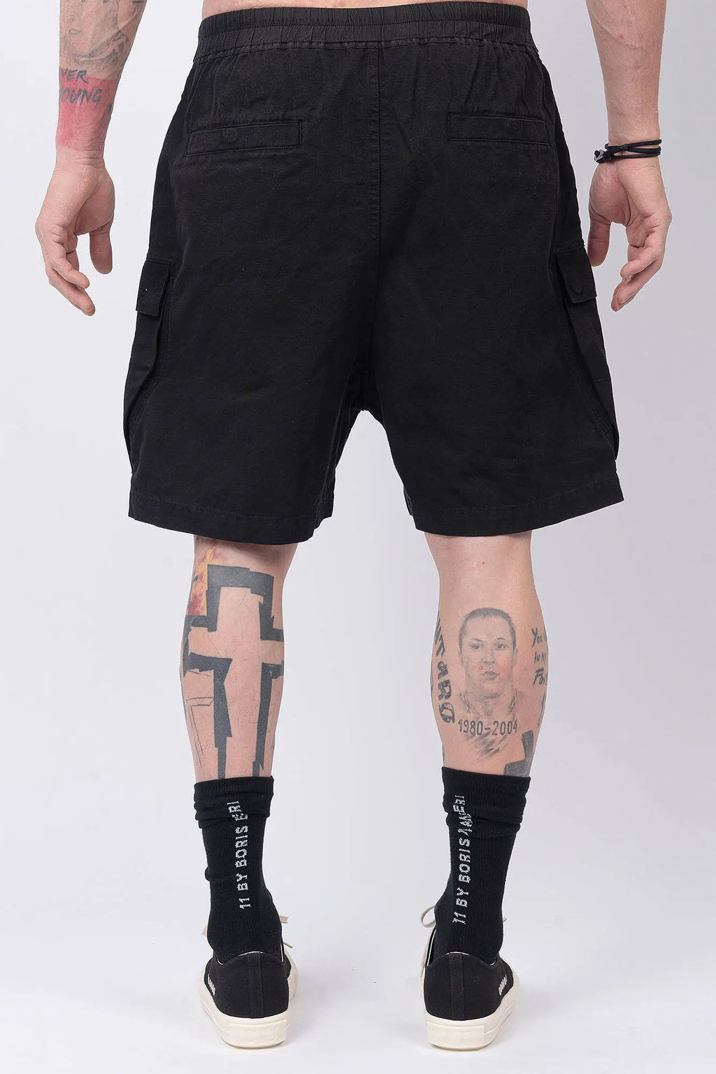 Rick Owens,Mens Shorts,Knee Lenght,Low Crotch,Wide Leg,Elastic Waistband With Drawstrings,Bela Exposed Center Zipper With Two Snap Detail,Two Side Beveled Cargo Pockets With Concealed Snaps And Topstitching , Two Rear Welt Pockets With Concealed Snaps And Topstitching, Lightweight Wash Milk Denim,Black And Natural 8OZ Denim,Dyed,Waxed By Hand,Back View.