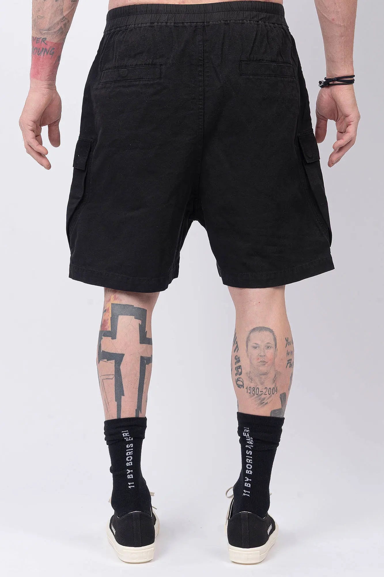Rick Owens,Mens Shorts,Knee Lenght,Low Crotch,Wide Leg,Elastic Waistband With Drawstrings,Bela Exposed Center Zipper With Two Snap Detail,Two Side Beveled Cargo Pockets With Concealed Snaps And Topstitching , Two Rear Welt Pockets With Concealed Snaps And Topstitching, Lightweight Wash Milk Denim,Black And Natural 8OZ Denim,Dyed,Waxed By Hand,Back View.