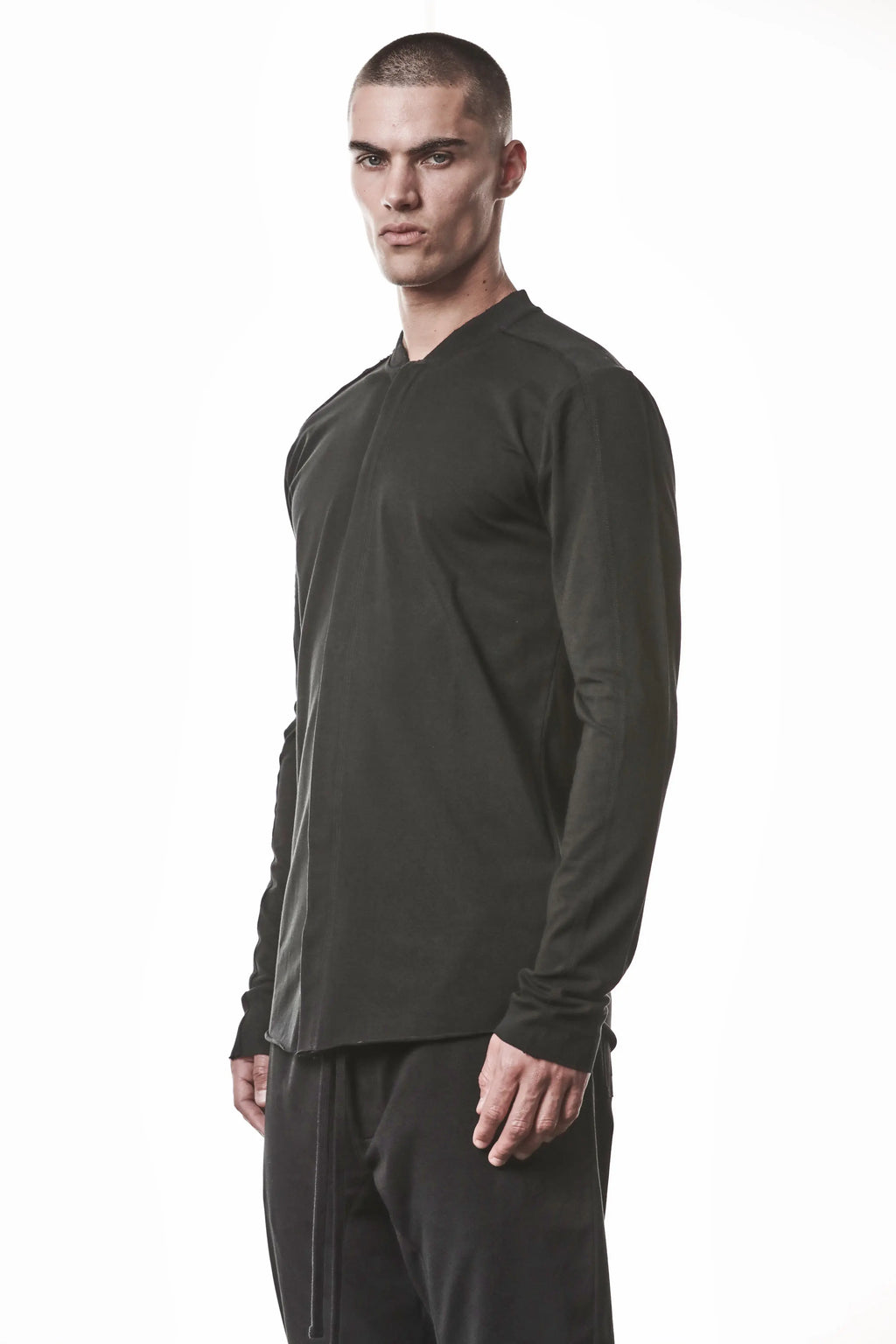 Thom Krom, Mens Shirt, Black, Stretch Sleeves, Exposed Seams, Stitched Logo, Thom/Krom, The Night is your friend, my love, Long Sleeves, Ribbed Collar, Front Portrait 3/4 View. 