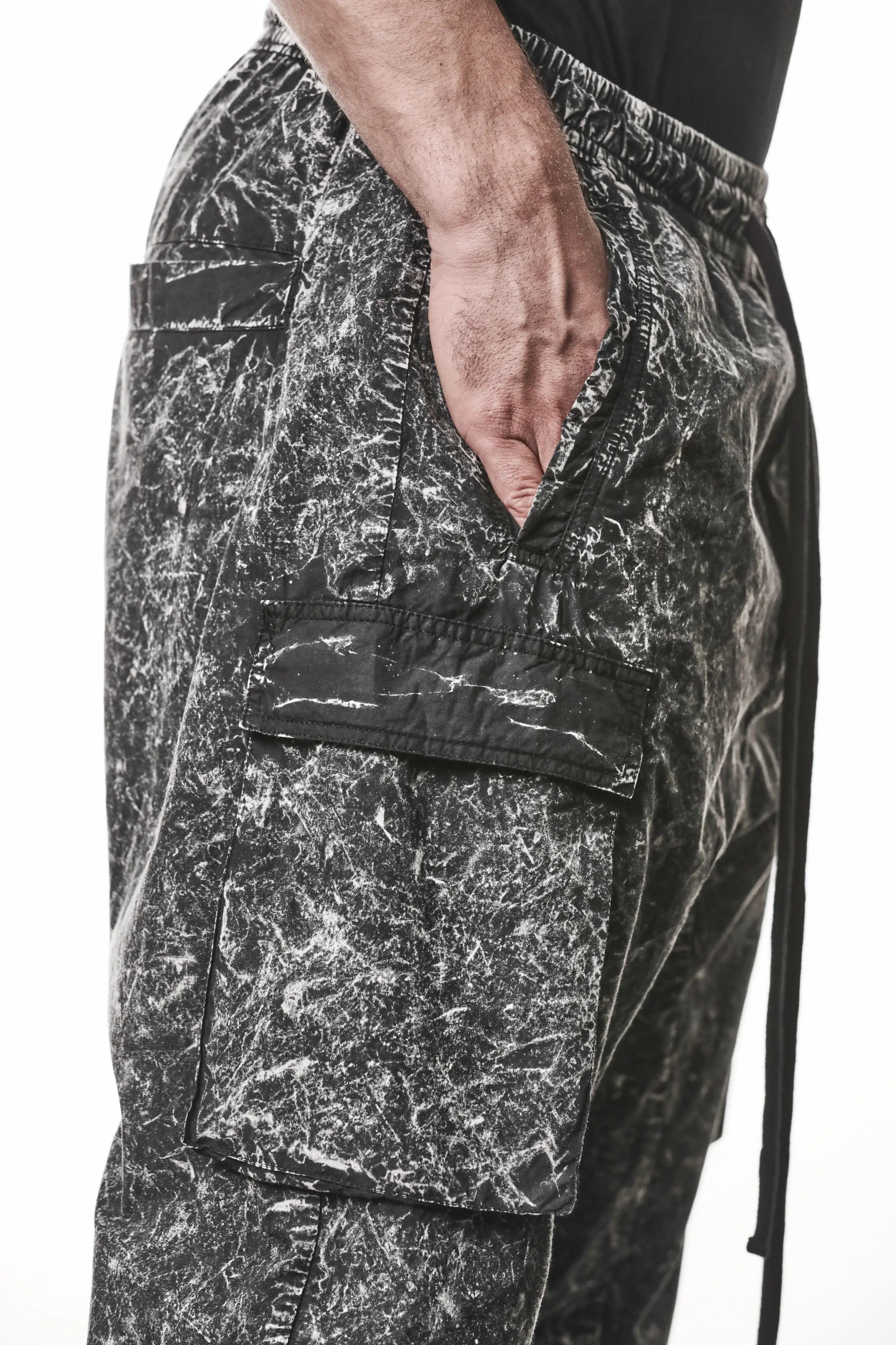 Thom Krom, Mens Trousers, Black, Cargo Pants, Zip Pockets, Side Pockets, Drawstring, Elasticated Waistband, Elasticated Ankle Cuffs, Drop-Crotch, Back Pockets, YKK Zippers, Side View Hand in Pocket. 