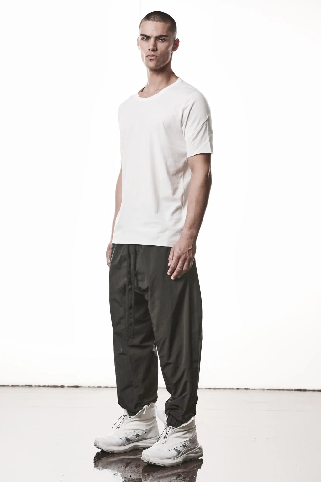 Thom Krom, Mens T-Shirt, White, Cotton Jersey with breathability Inserts, Viscose Linen Inserts, Crewneck, Short Sleeves, Lightweight, 100% Cotton, Signature Cross Black Seams, The Night is your friend, my love, Full Body 3/4 Front Photo. 