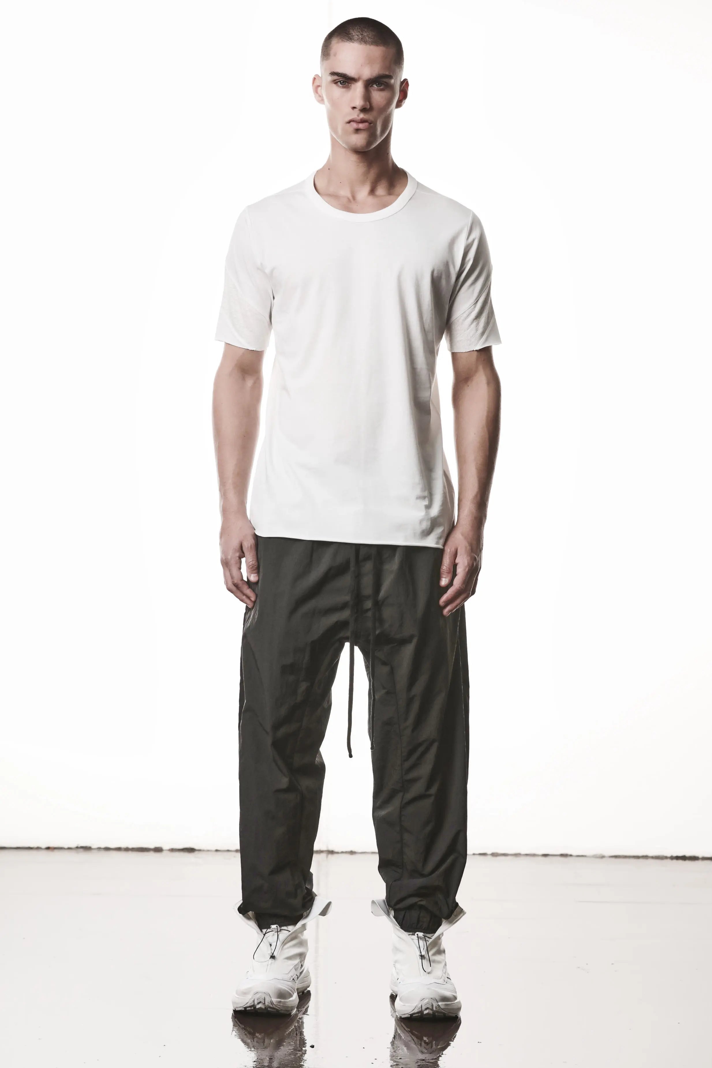 Thom Krom, Mens T-Shirt, White, Cotton Jersey with breathability Inserts, Viscose Linen Inserts, Crewneck, Short Sleeves, Lightweight, 100% Cotton, Signature Cross Black Seams, The Night is your friend, my love, Full Body Front View. 