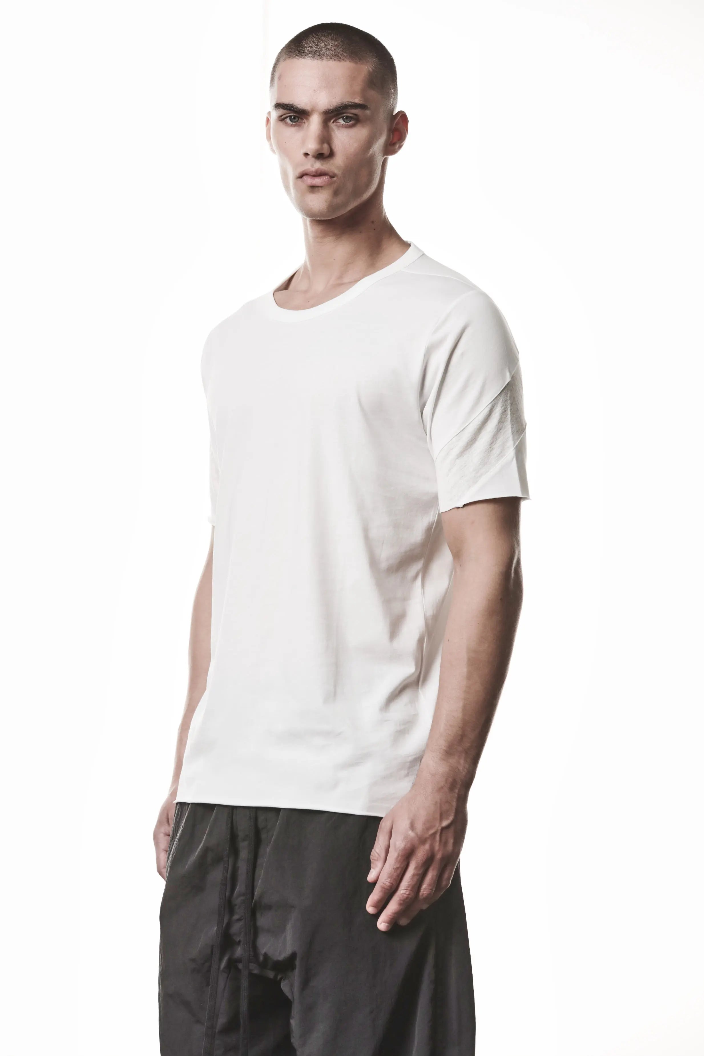 Thom Krom, Mens T-Shirt, White, Cotton Jersey with breathability Inserts, Viscose Linen Inserts, Crewneck, Short Sleeves, Lightweight, 100% Cotton, Signature Cross Black Seams, The Night is your friend, my love, 3/4 Front View. 