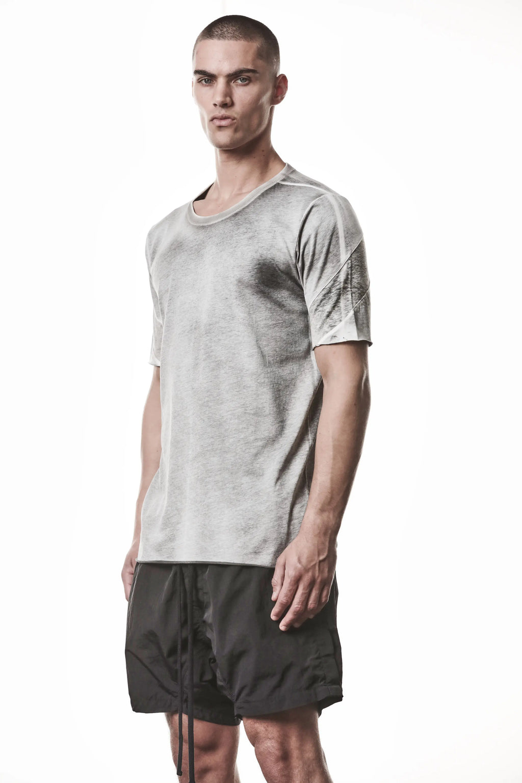 Thom Krom, Mens T-Shirt, Spray Grey, Cotton Jersey with breathability Inserts, Viscose Linen Inserts, Crewneck, Short Sleeves, Lightweight, 100% Cotton, Signature Cross Back Seams, The Night is your friend, my love, 3/4 Front Portrait Photo. 