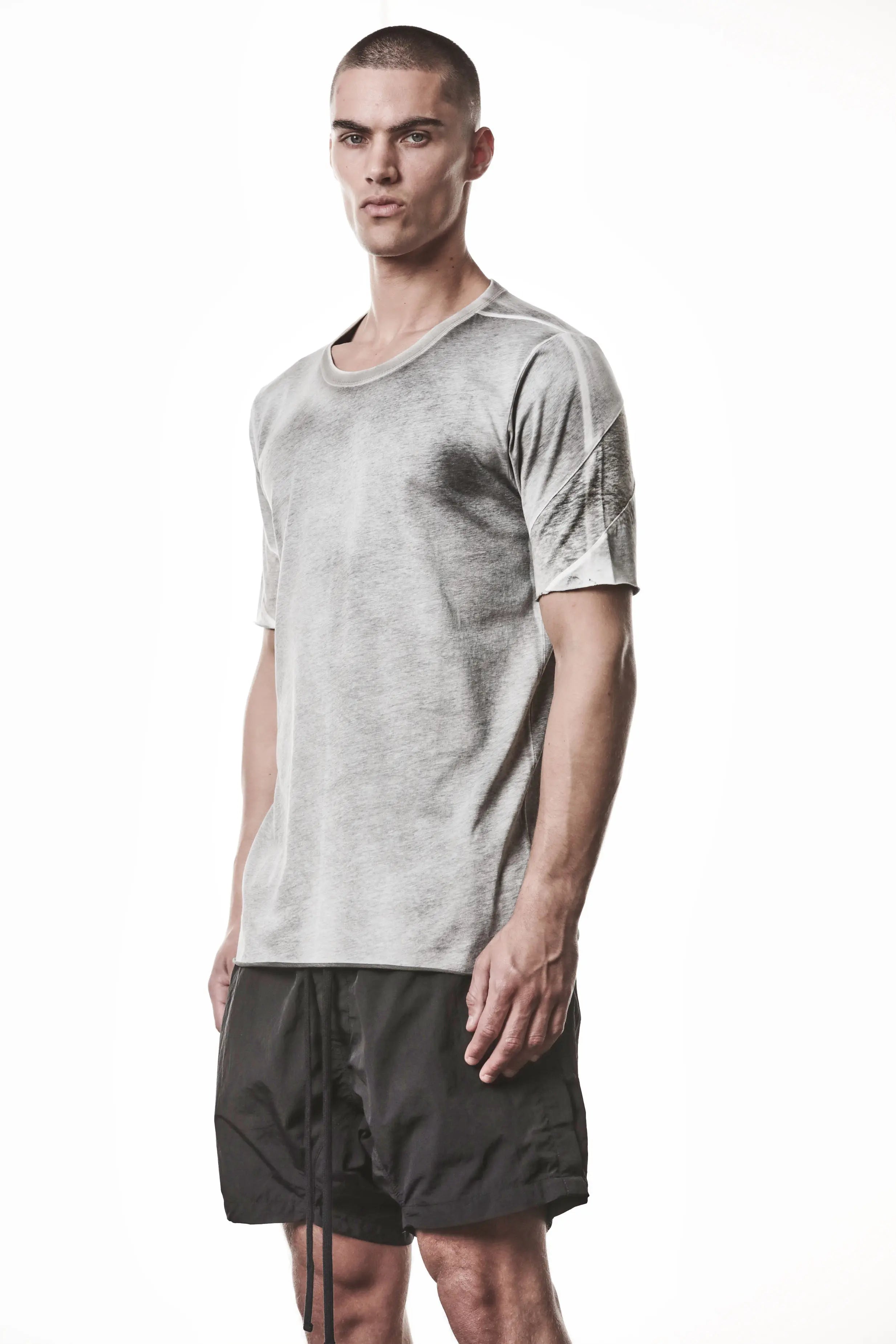 Thom Krom, Mens T-Shirt, Spray Grey, Cotton Jersey with breathability Inserts, Viscose Linen Inserts, Crewneck, Short Sleeves, Lightweight, 100% Cotton, Signature Cross Back Seams, The Night is your friend, my love, 3/4 Front Portrait Photo. 