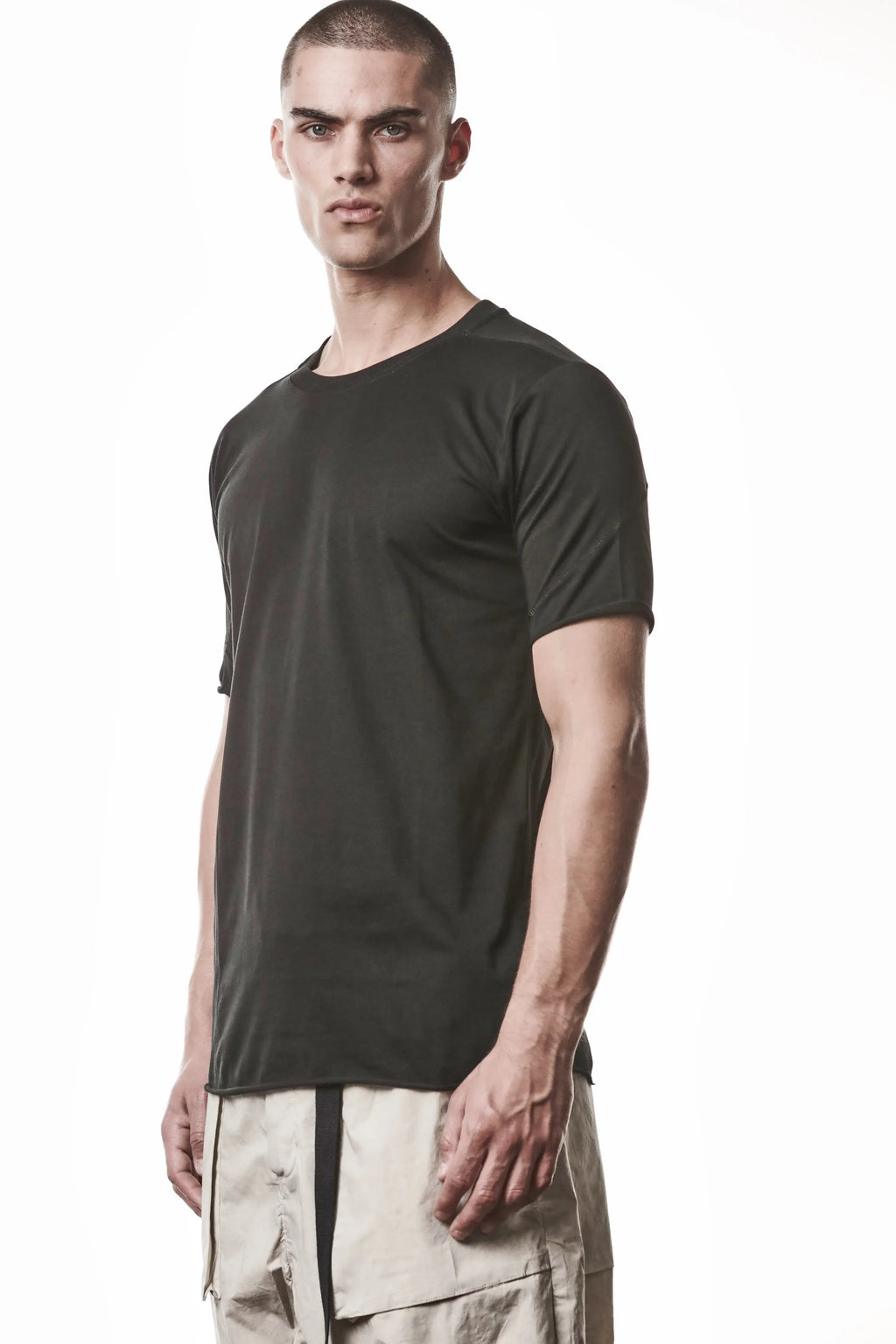 Thom Krom, Mens T-Shirt, Black, Raw-Cut Hem, Elastic Neck, 100% Cotton, Short Sleeves, Crewneck, Round Neck, White Cross Seams, Back Seams, Embroidered Logo, Front Portrait 3/4 View. 