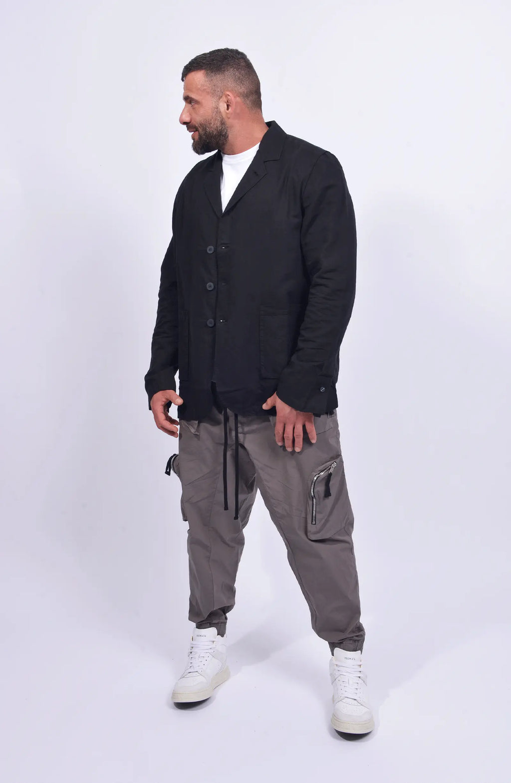 Thom Krom, Mens Blazer, Black, Buttons, V-Neck, Collar, Patch Pockets, Long Sleeves, White T-Shirt, Side Pockets, Slit in Back, Woven, Full Body Front View Looking Sideways. 