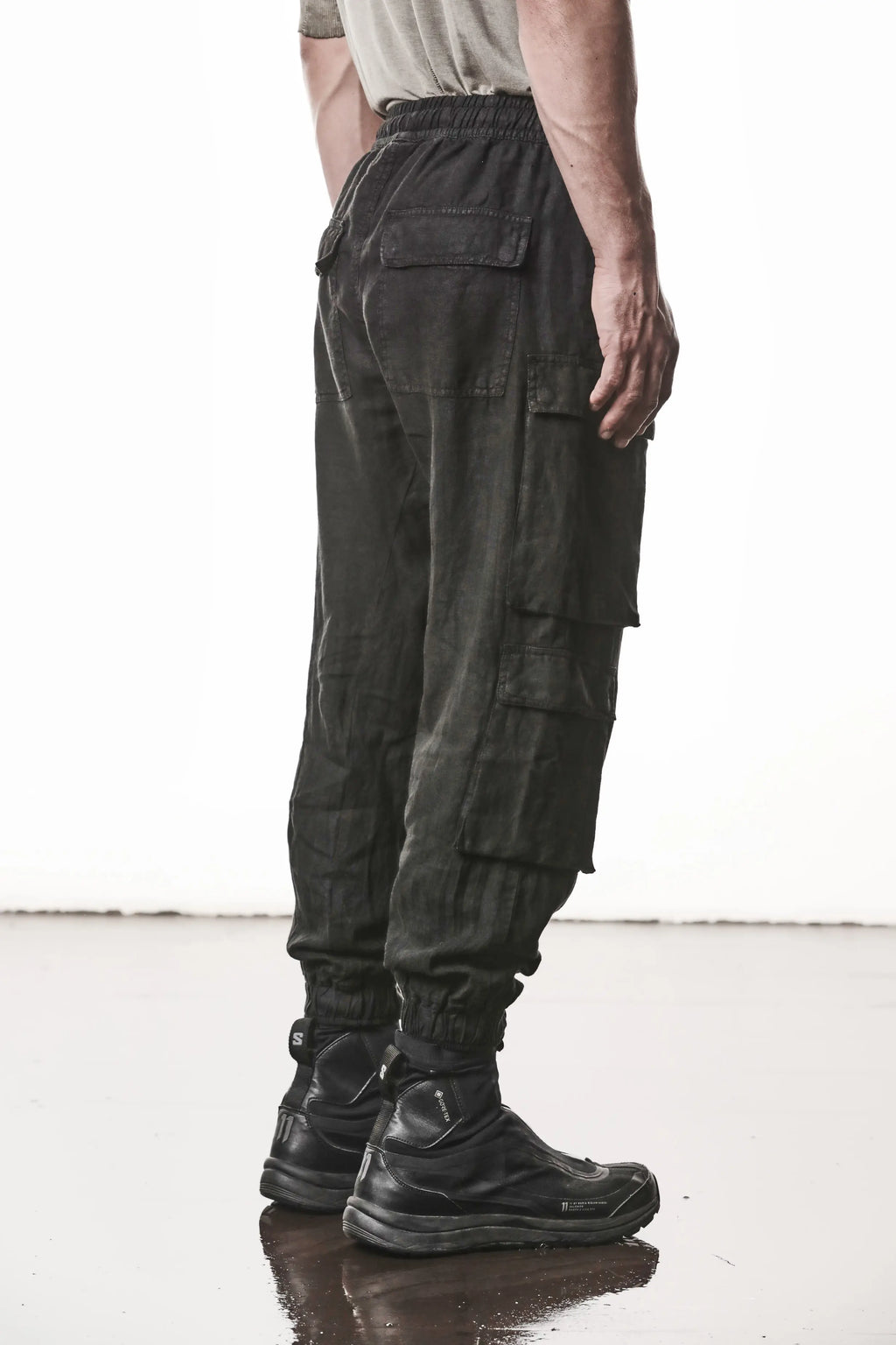 Thom Krom, Mens Pants, Black, Linen, Elasticated Waistband and Cuffs, Low-Crotch Trousers, Cargo Details, Black Drawstring, Side Pockets, Back Pockets, Back 3/4 View. 