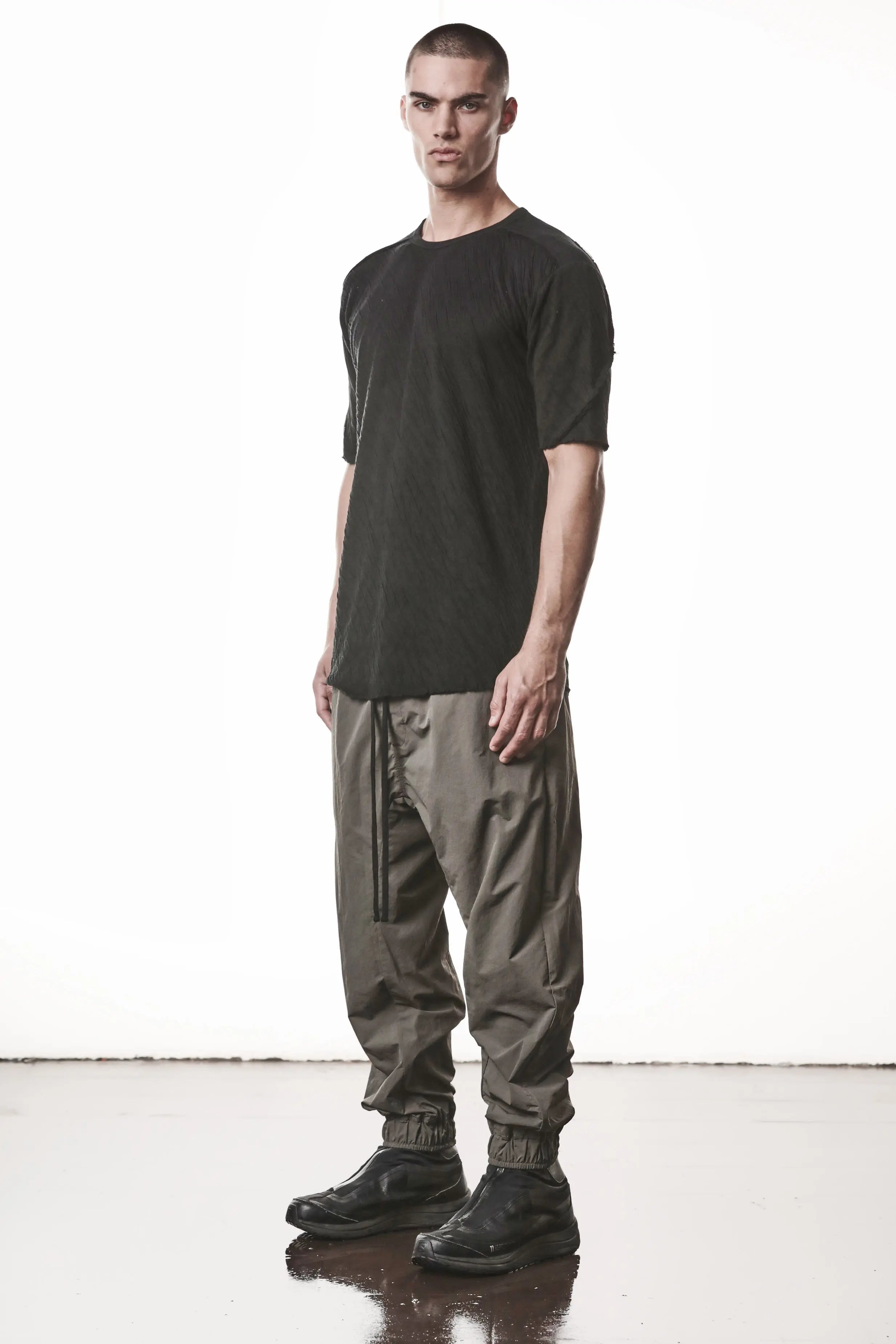 Thom Krom T-Shirt,Mens T-Shirt,Black Cotton,Raw Cut Hem,Raw Cut Sleeves,Round Crewneck,Slim Fit,Lightweight Crashed Bonded Cotton, Signature Front Level Shoulder Seams,Asymetric Sleeve Seams,Side Angle Whole Body Photo