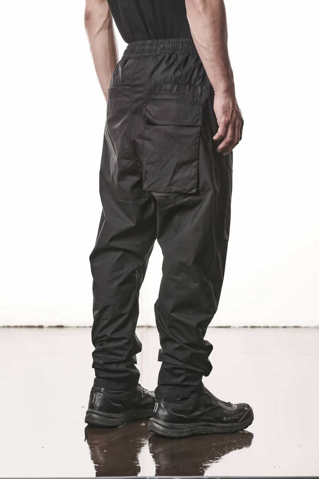 Thom Krom, Mens Pants, Black, Oversized, Wide-fit, Loose-fit, Large Front Pockets, Side Pockets, Back Pockets, Elasticated Waistband, Black Drawstring, Zip Pockets, YKK Zippers, Wide Ankles, Back 3/4 Portrait. 