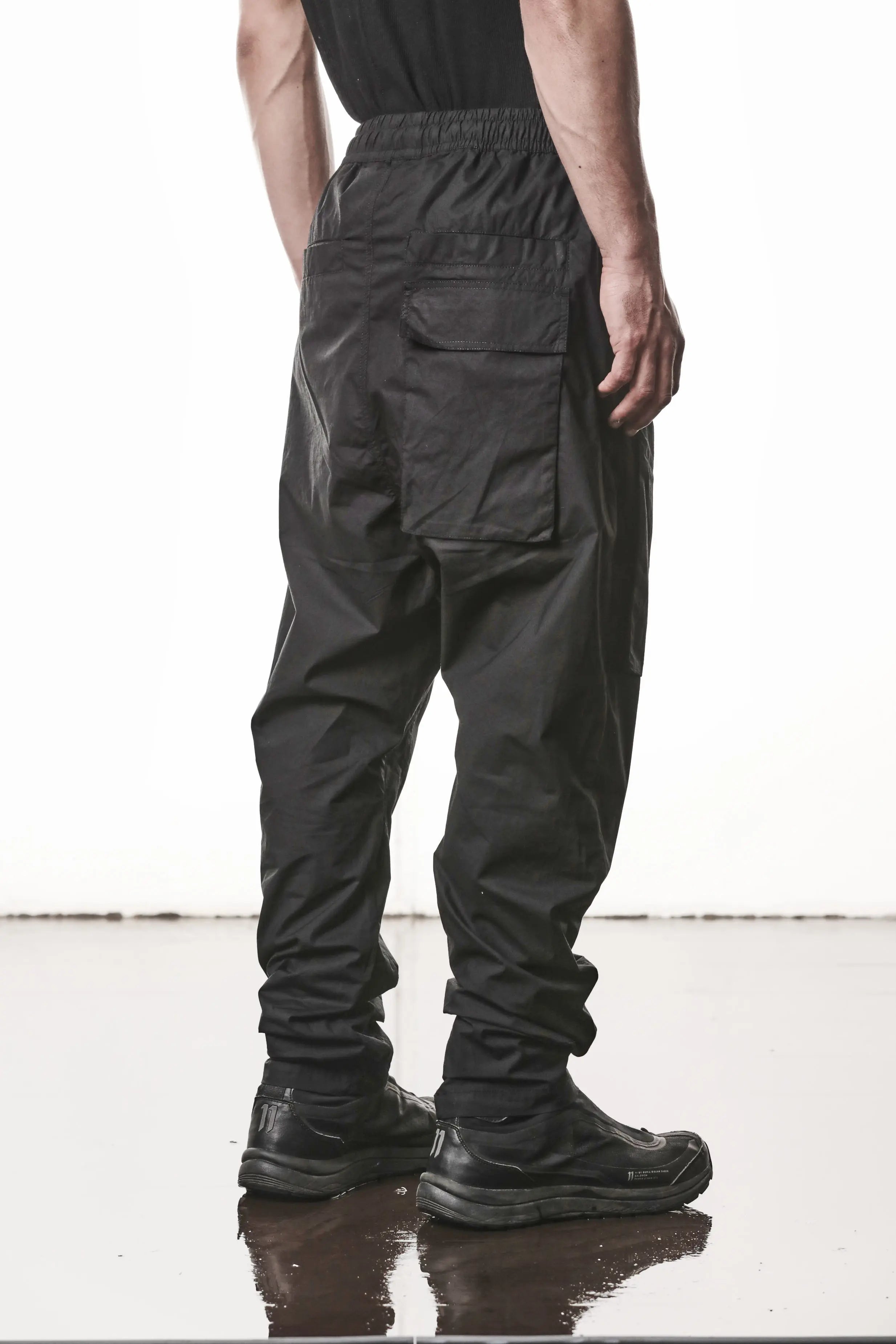 Thom Krom, Mens Pants, Black, Oversized, Wide-fit, Loose-fit, Large Front Pockets, Side Pockets, Back Pockets, Elasticated Waistband, Black Drawstring, Zip Pockets, YKK Zippers, Wide Ankles, Back 3/4 Portrait. 