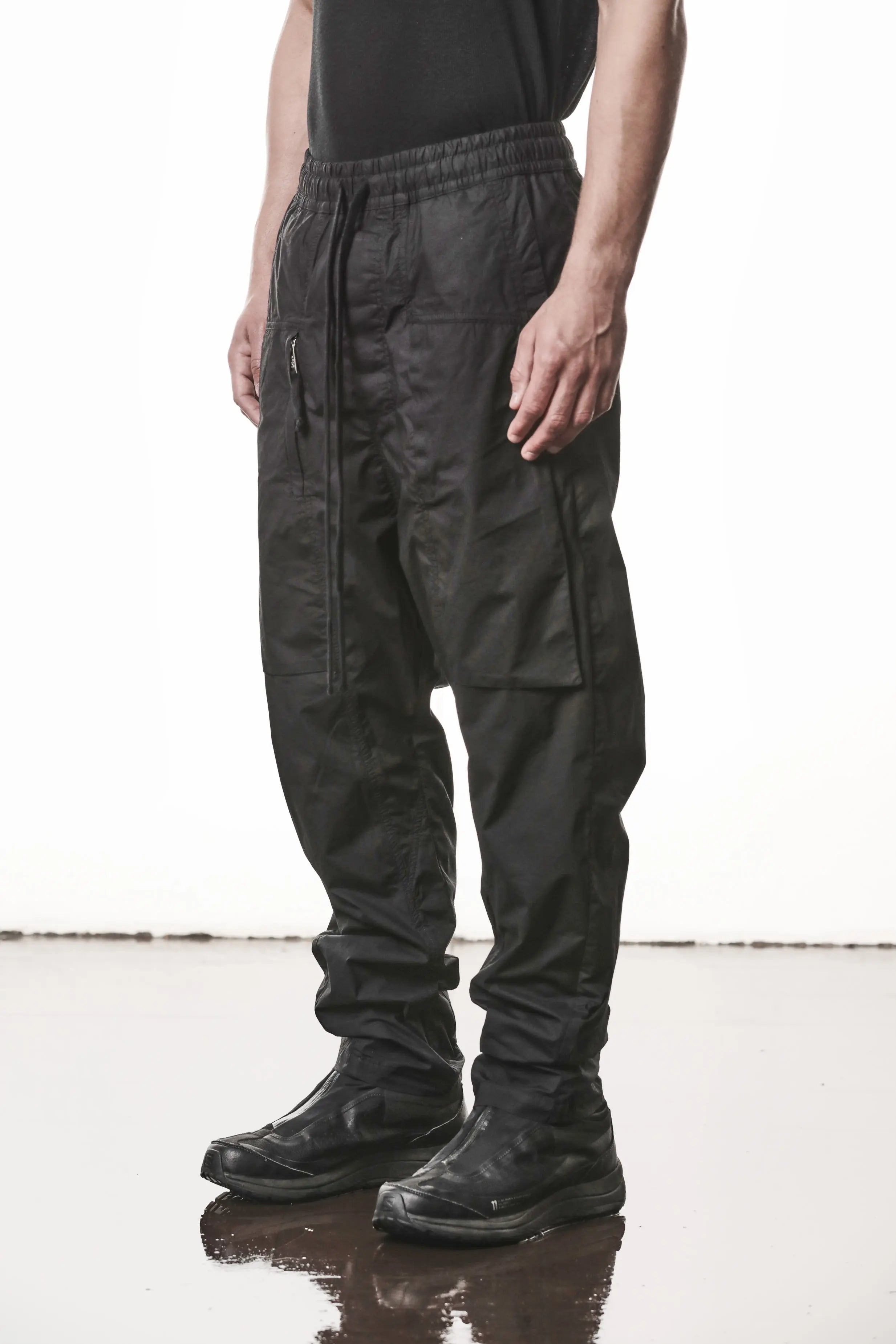 Thom Krom, Mens Pants, Black, Oversized, Wide-fit, Loose-fit, Large Front Pockets, Side Pockets, Back Pockets, Elasticated Waistband, Black Drawstring, Zip Pockets, YKK Zippers, Wide Ankles, Front 3/4 View. 