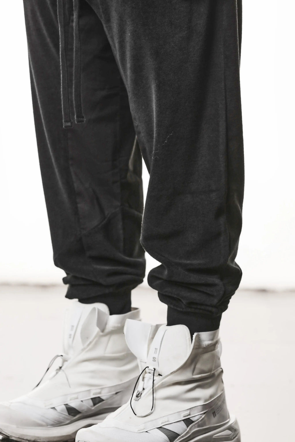 Thom Krom, Mens Pants, Black, Cotton Terry, Elasticated Waistband, Drawstring, Inserts, Side Pockets, Back Pockets, Ribbed Cuffs, The night is your friend, my love, Front 3/4 View Leg Close-up. 