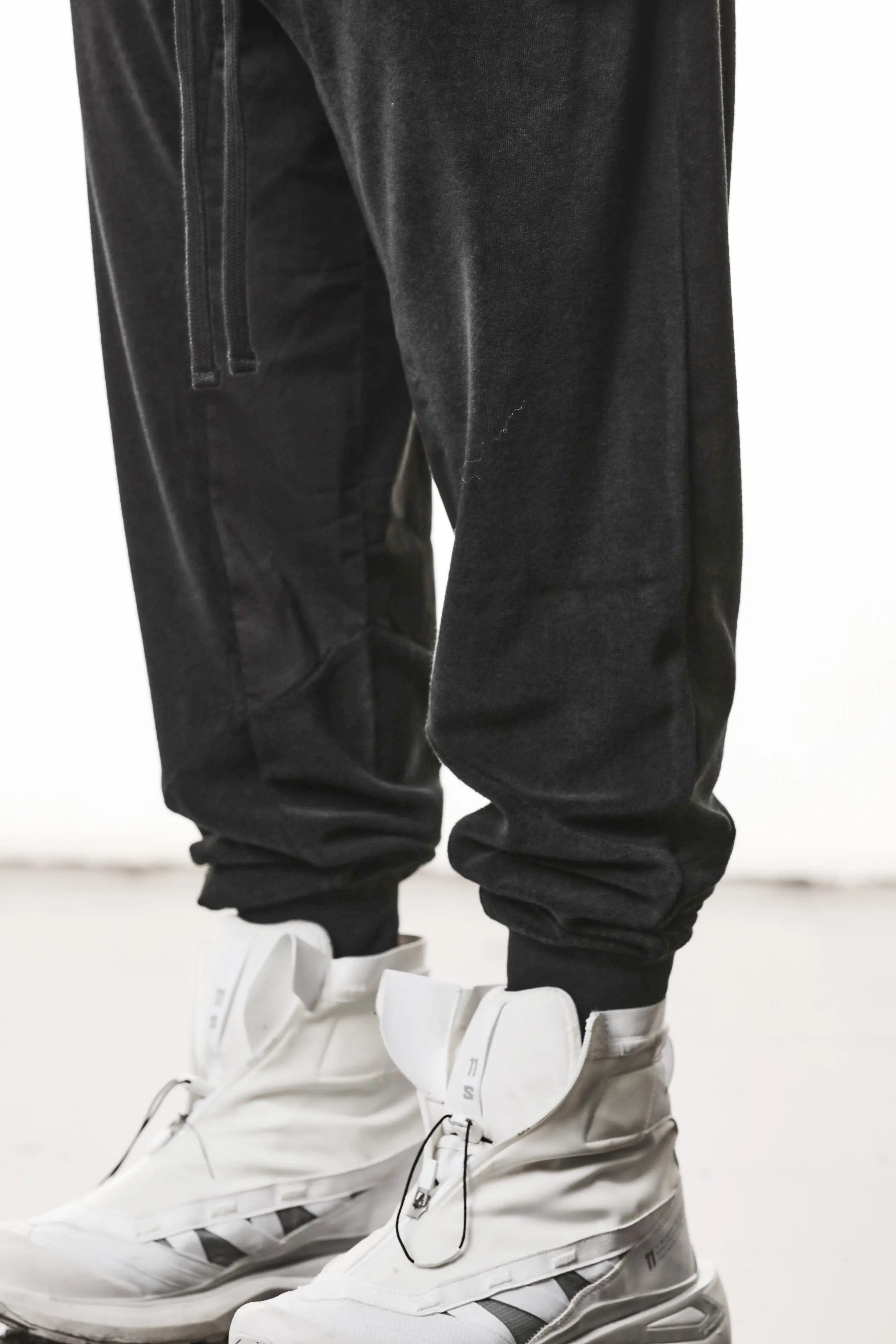 Thom Krom, Mens Pants, Black, Cotton Terry, Elasticated Waistband, Drawstring, Inserts, Side Pockets, Back Pockets, Ribbed Cuffs, The night is your friend, my love, Front 3/4 View Leg Close-up. 
