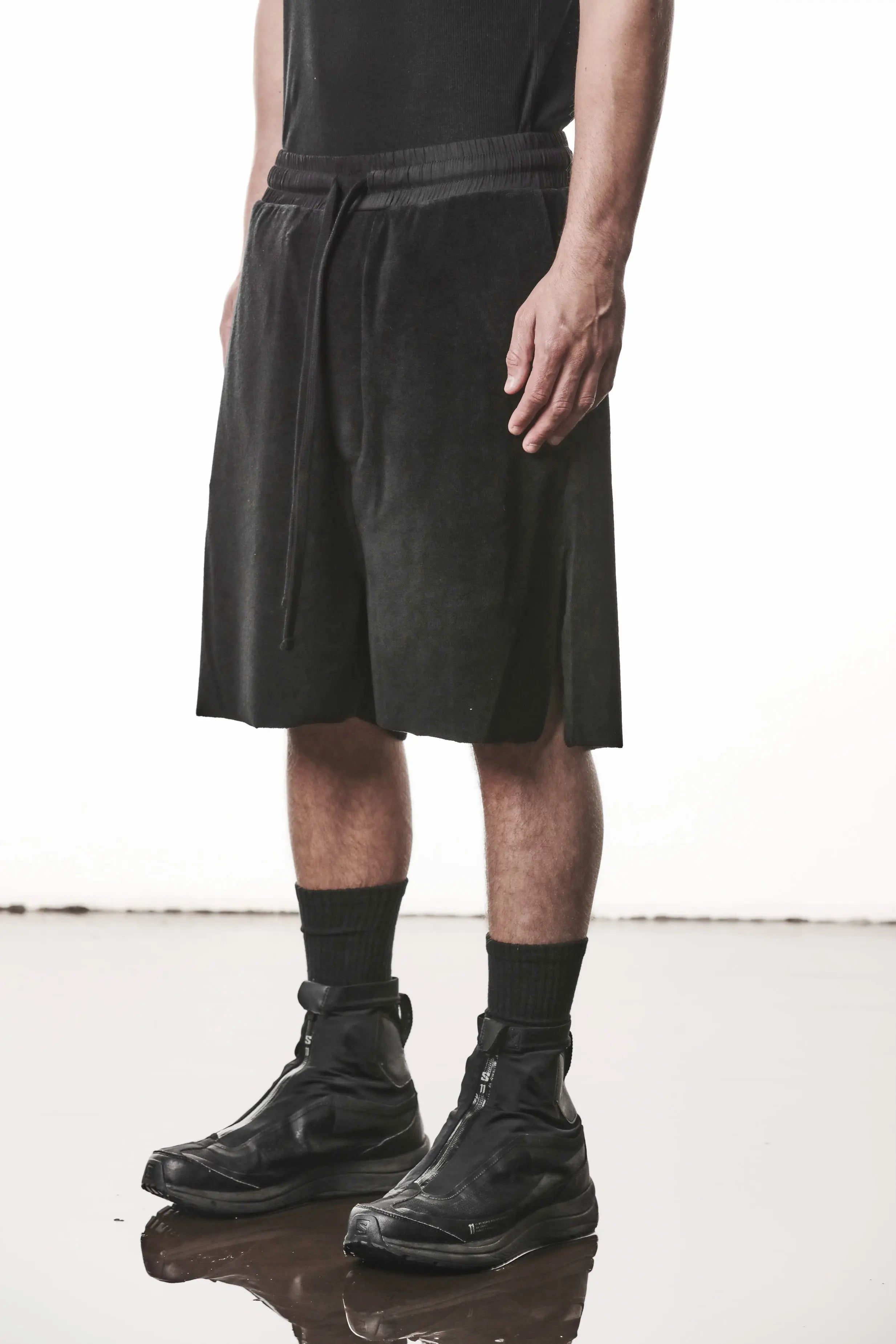 Thom Krom, Mens Shorts, Black, Elasticated Waistband, Drawstring, Raw cut hem and slits, Cotton Terry, Woven Inserts, 1/2 Legs, Side Pockets, Front Portrait 3/4 View. 
