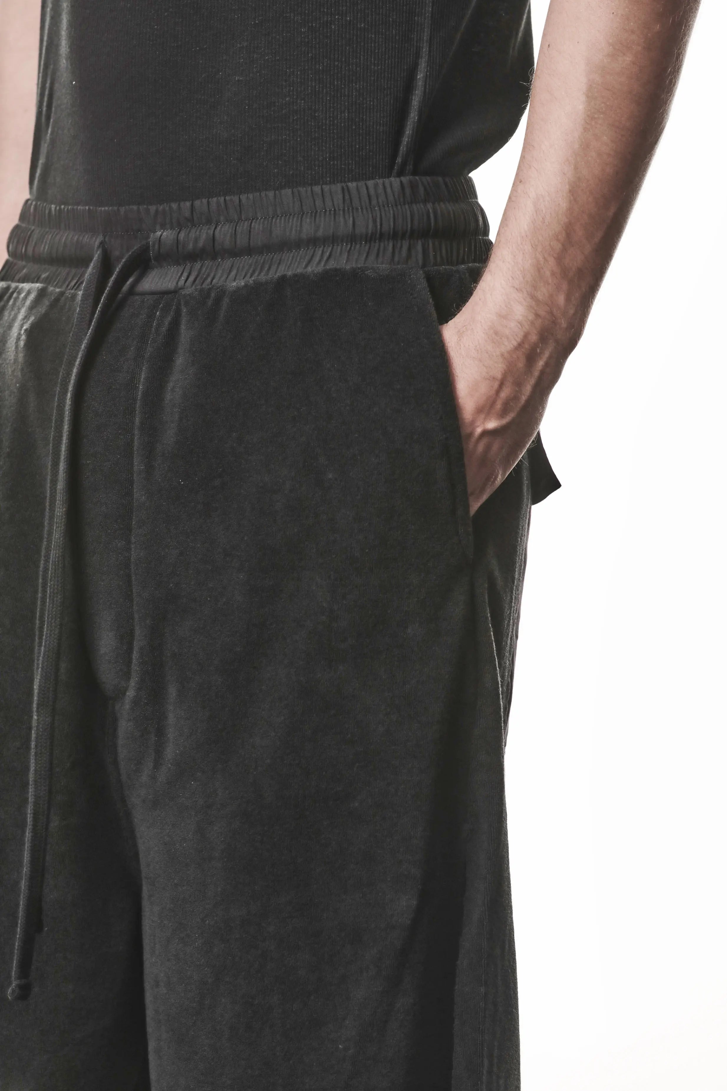 Thom Krom, Mens Shorts, Black, Elasticated Waistband, Drawstring, Raw cut hem and slits, Cotton Terry, Woven Inserts, 1/2 Legs, Side Pockets, Hand in Pocket Close-up. 