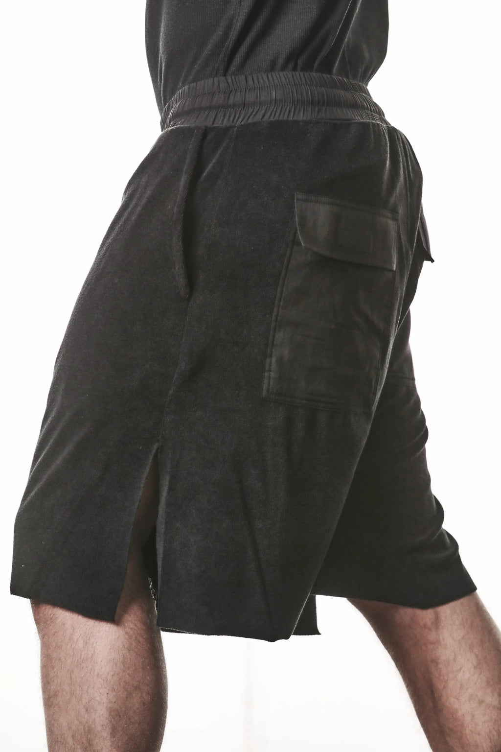 Thom Krom, Mens Shorts, Black, Elasticated Waistband, Drawstring, Raw cut hem and slits, Cotton Terry, Woven Inserts, 1/2 Legs, Side Pockets, Step Forward Side View. 