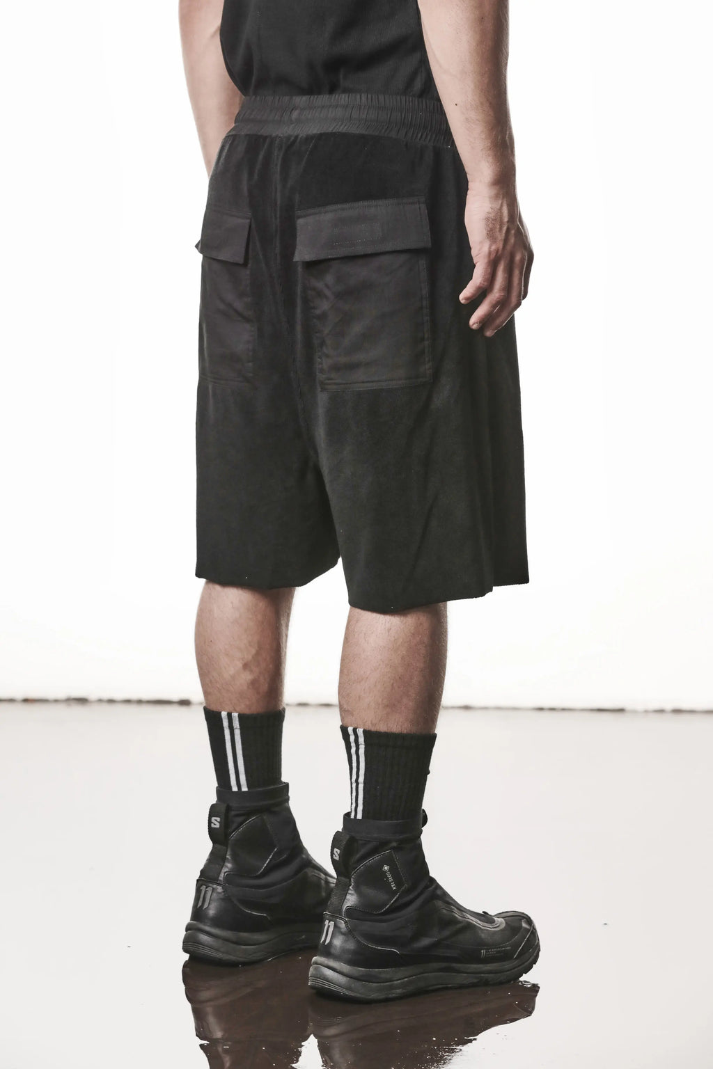 Thom Krom, Mens Shorts, Black, Elasticated Waistband, Drawstring, Raw cut hem and slits, Cotton Terry, Woven Inserts, 1/2 Legs, Side Pockets, Back 3/4 View. 