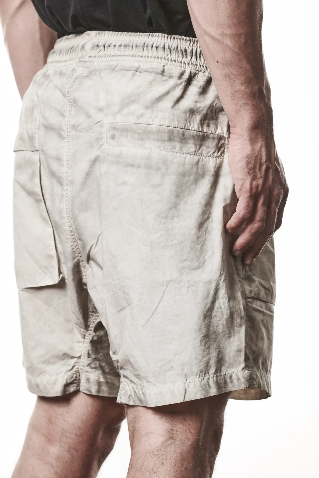 Thom Krom, Mens Shorts, Vegetal Stone, Beige, Elasticated Waistband, Drawsting, Funtional Front and Side Pockets, YKK Zipper, Zip Fly, Wide-fit, Above the Knee, Back 3/4 Close-up View. 