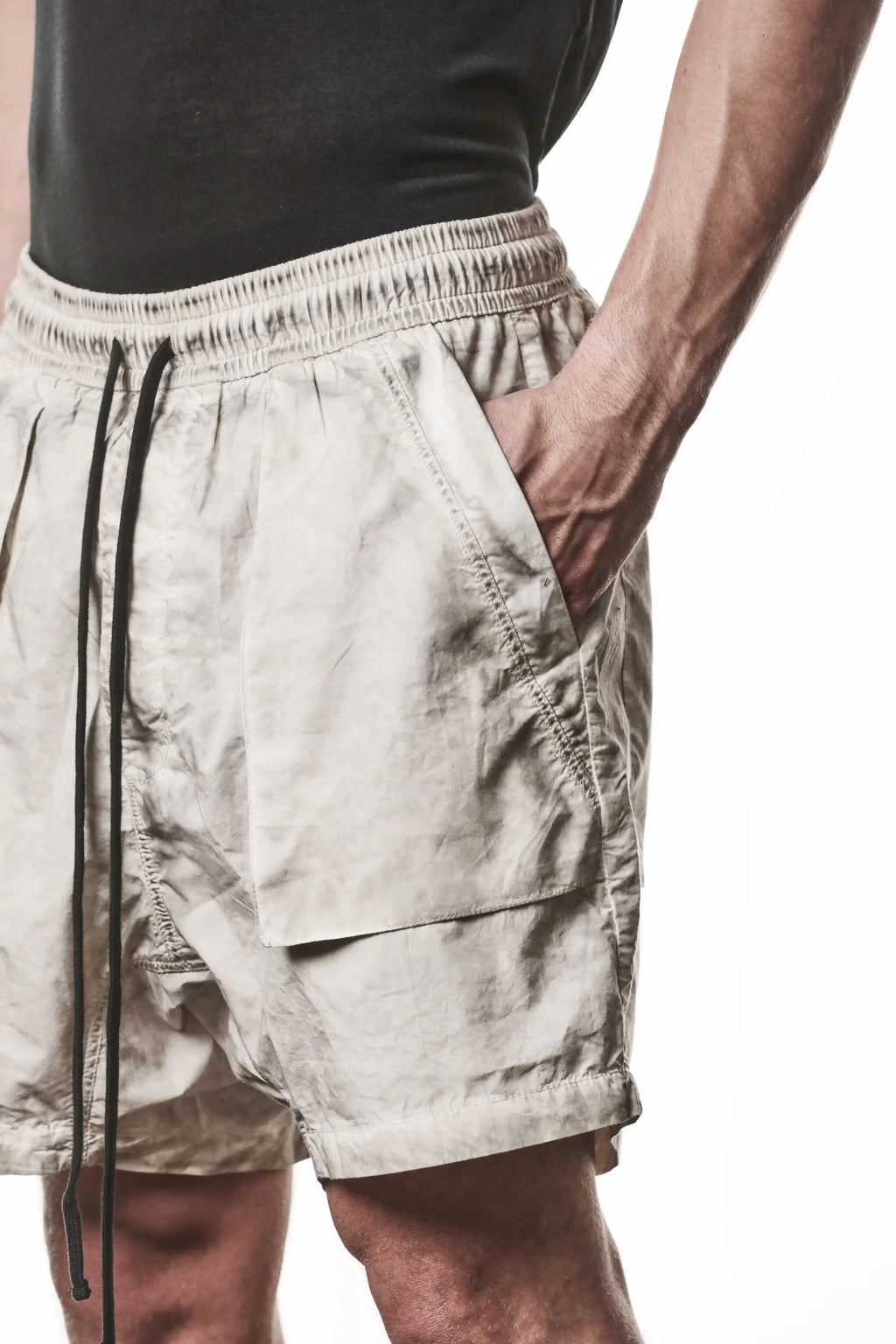 Thom Krom, Mens Shorts, Vegetal Stone, Beige, Elasticated Waistband, Drawsting, Funtional Front and Side Pockets, YKK Zipper, Zip Fly, Wide-fit, Above the Knee, Front 3/4 Close-up Hand in Pocket. 