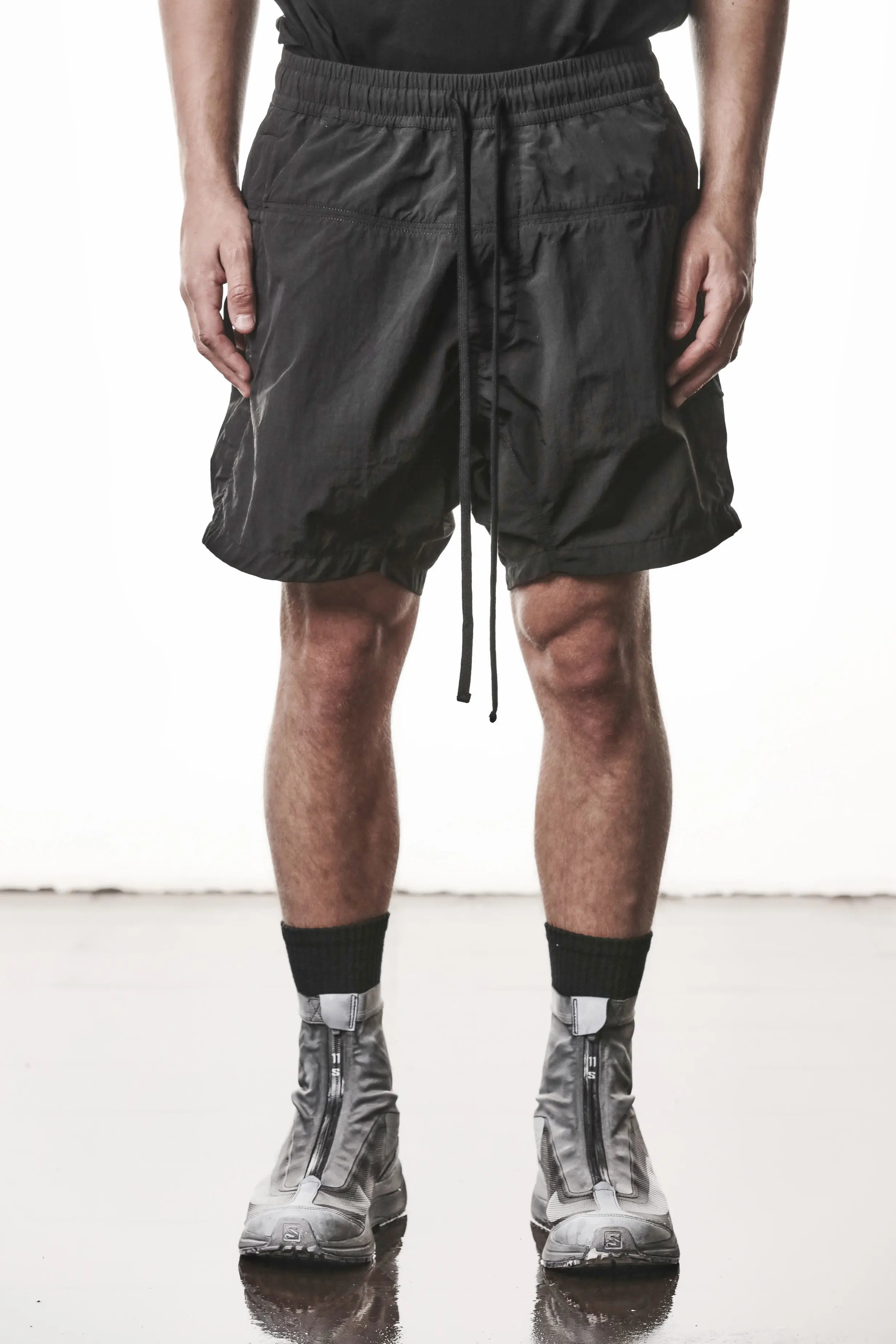 Thom Krom, Mens Shorts, Black, Polyamide, Side Pockets, Elasticated Waistband, Drawsting, Cross Seams, Wide Fit, Over the Knee Legs, Drop-Crotch, Hidden Zip Pockets, Front View. 