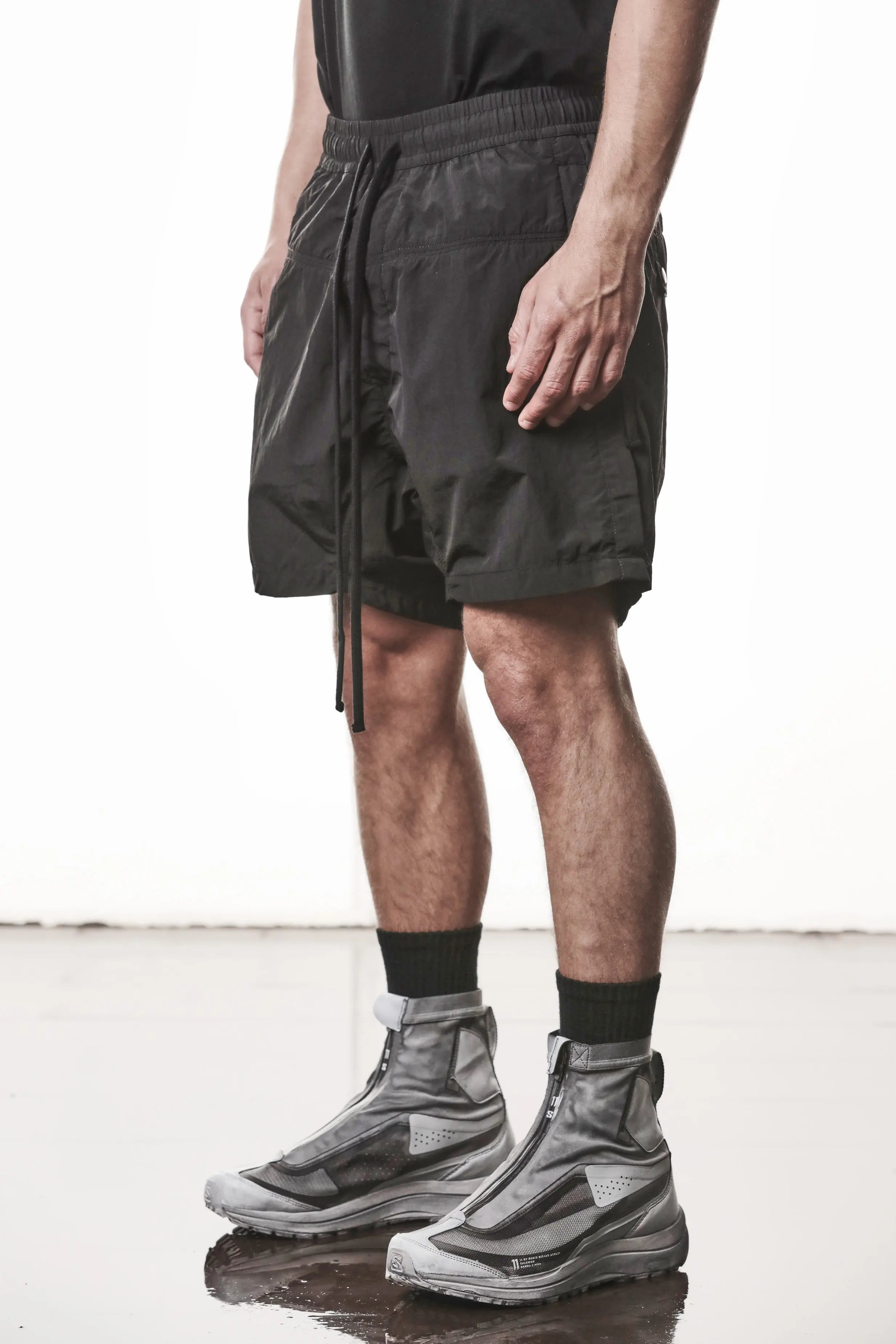 Thom Krom, Mens Shorts, Black, Polyamide, Side Pockets, Elasticated Waistband, Drawsting, Cross Seams, Wide Fit, Over the Knee Legs, Drop-Crotch, Hidden Zip Pockets, Front 3/4 View. 
