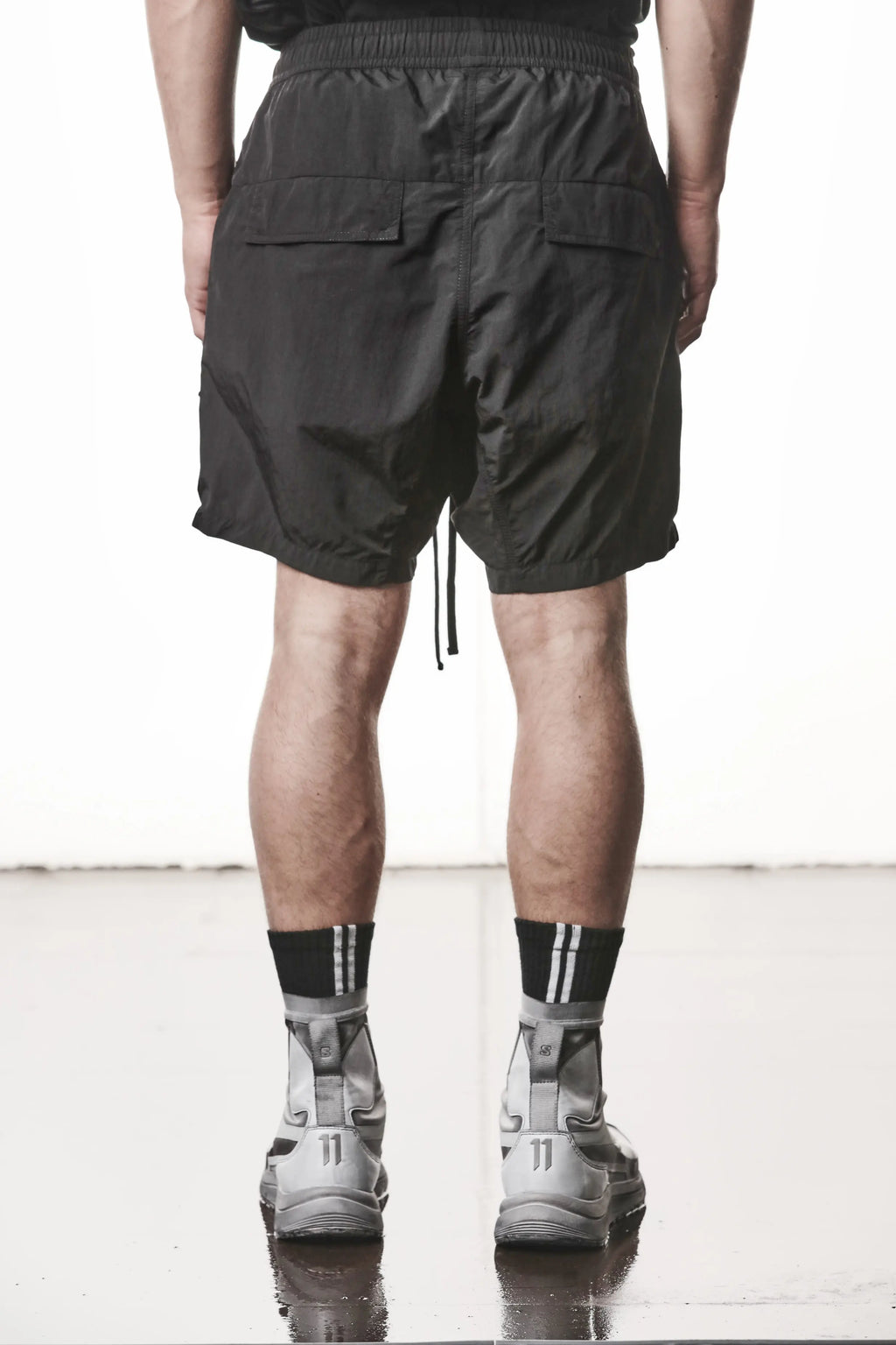 Thom Krom, Mens Shorts, Black, Polyamide, Side Pockets, Elasticated Waistband, Drawsting, Cross Seams, Wide Fit, Over the Knee Legs, Drop-Crotch, Hidden Zip Pockets, Back View. 