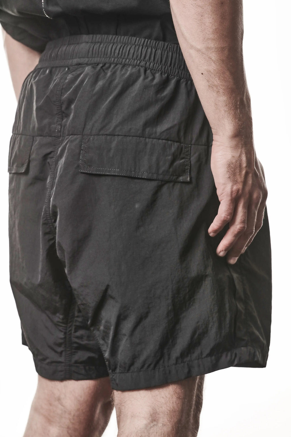 Thom Krom, Mens Shorts, Black, Polyamide, Side Pockets, Elasticated Waistband, Drawsting, Cross Seams, Wide Fit, Over the Knee Legs, Drop-Crotch, Hidden Zip Pockets, Close-up Back 3/4 View. 