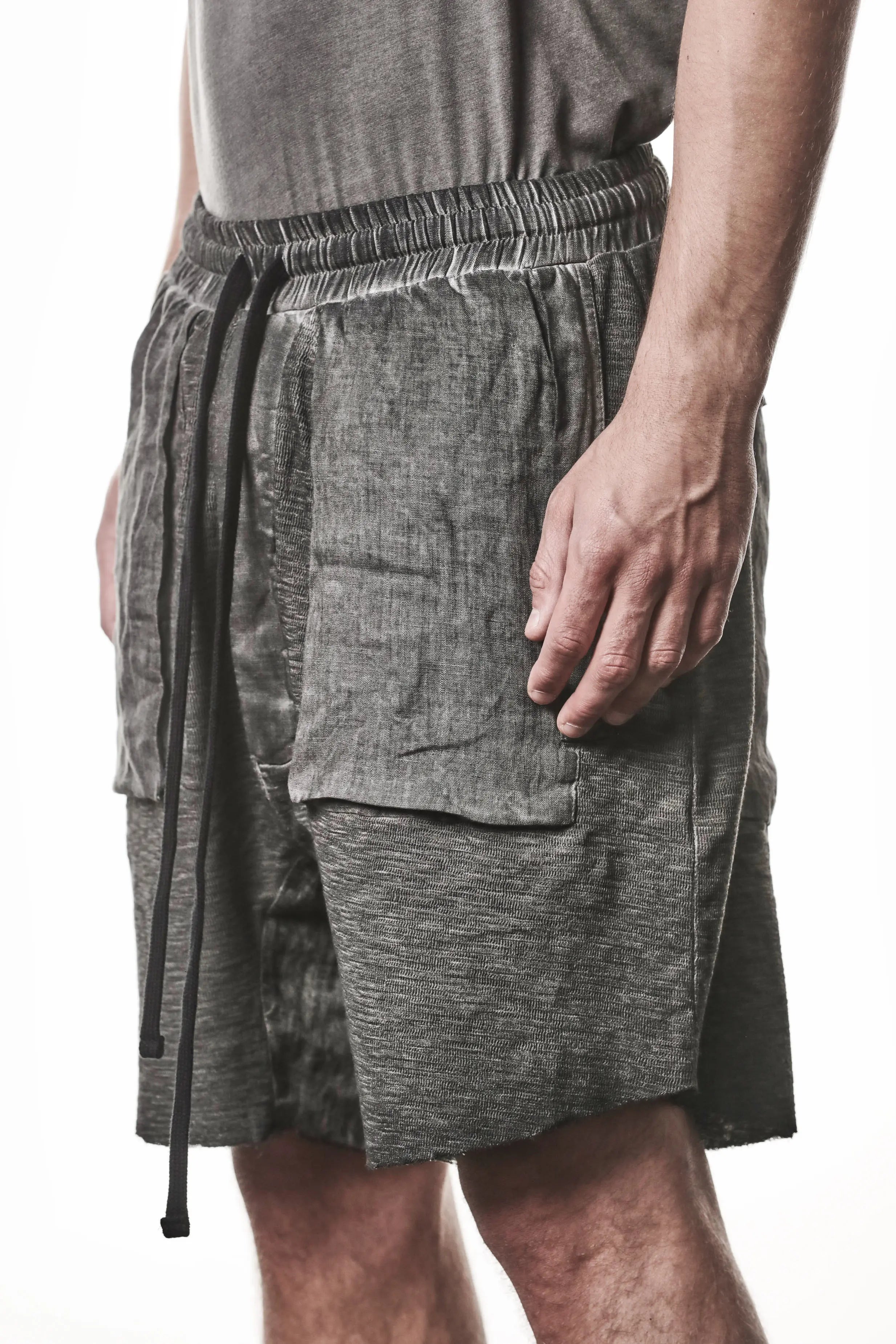 Thom Krom Shorts,Mens Shorts,Drop Crotch,Elasticated Waistband With Drawstrings,Regular Straight Fit,Raw Cut Hem Detailing,Lenght Above The Knee,Woven Linen Insert in Crotch,Bellow And Welt Pocket Construction,Hidden Zip Pockets At Front,Side Angle Close Up Photo