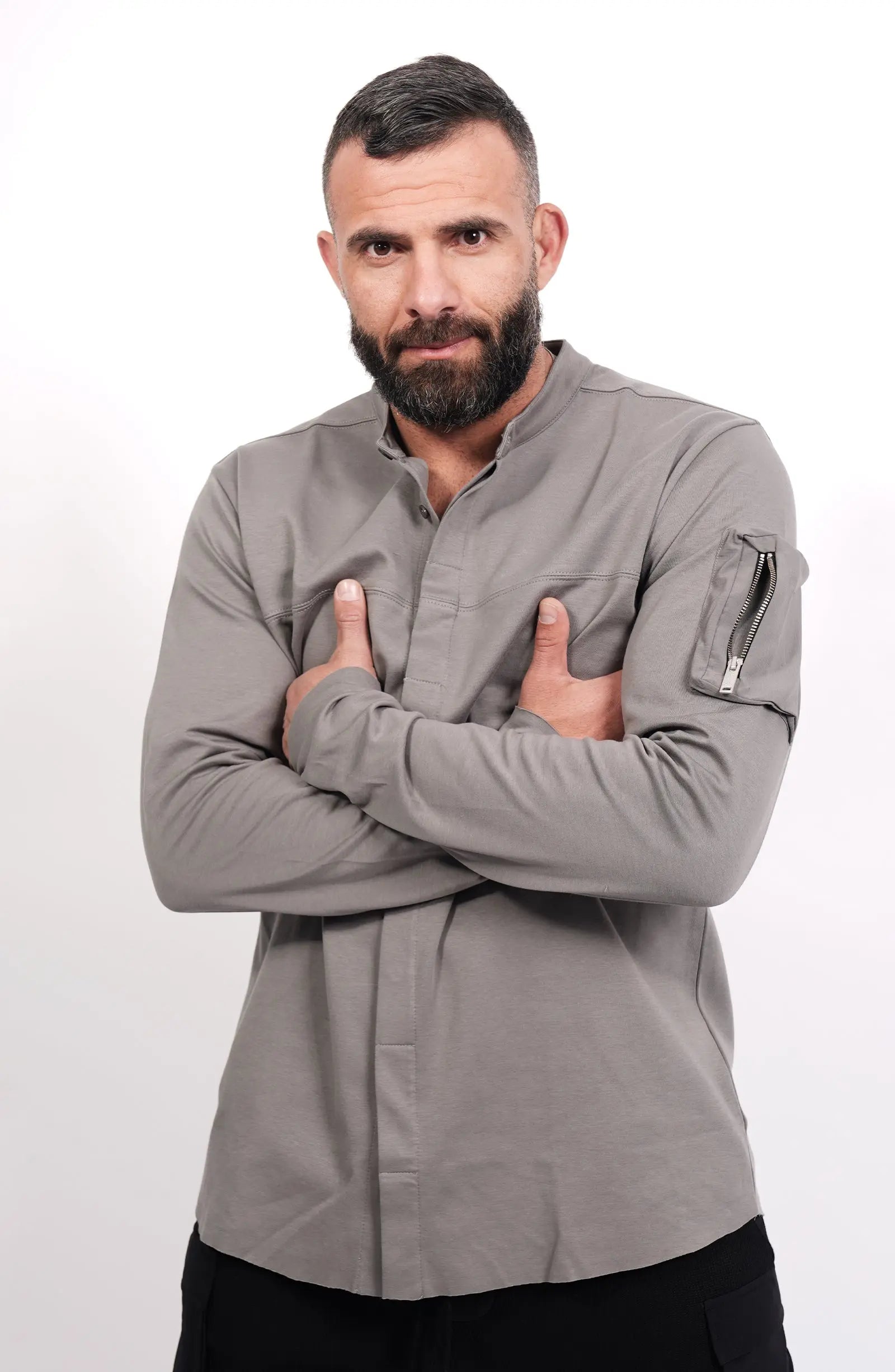 Thom Krom, Mens Shirt, Anthracite Grey, Long Sleeves, Hidden Placket, Sleeve Zip Pocket, Stand up Collar, Exposed Seams, Crossed Arms Portrait. 