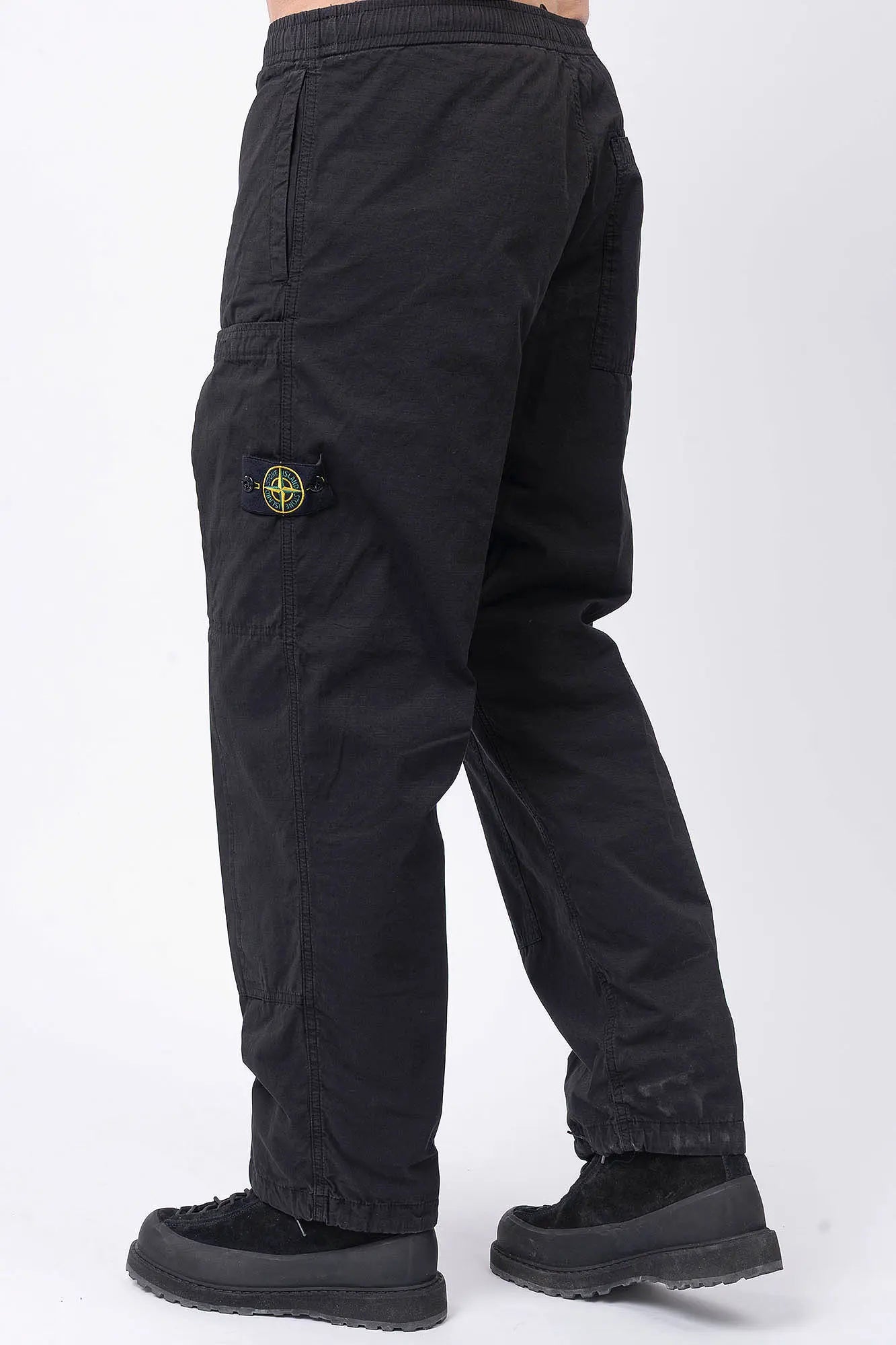Stone Island, Mens Pants, Black V0029, Mens Trousers, Side Pockets, Welt Pockets, Snap Closure Pockets, Compass Badge, Logo-patch, Signature Side Badge, Elasticated Ankle Cuffs, Elasticated Waistband, Side Pockets, Back Pockets, Back 3/4 View Stepping Forward. 