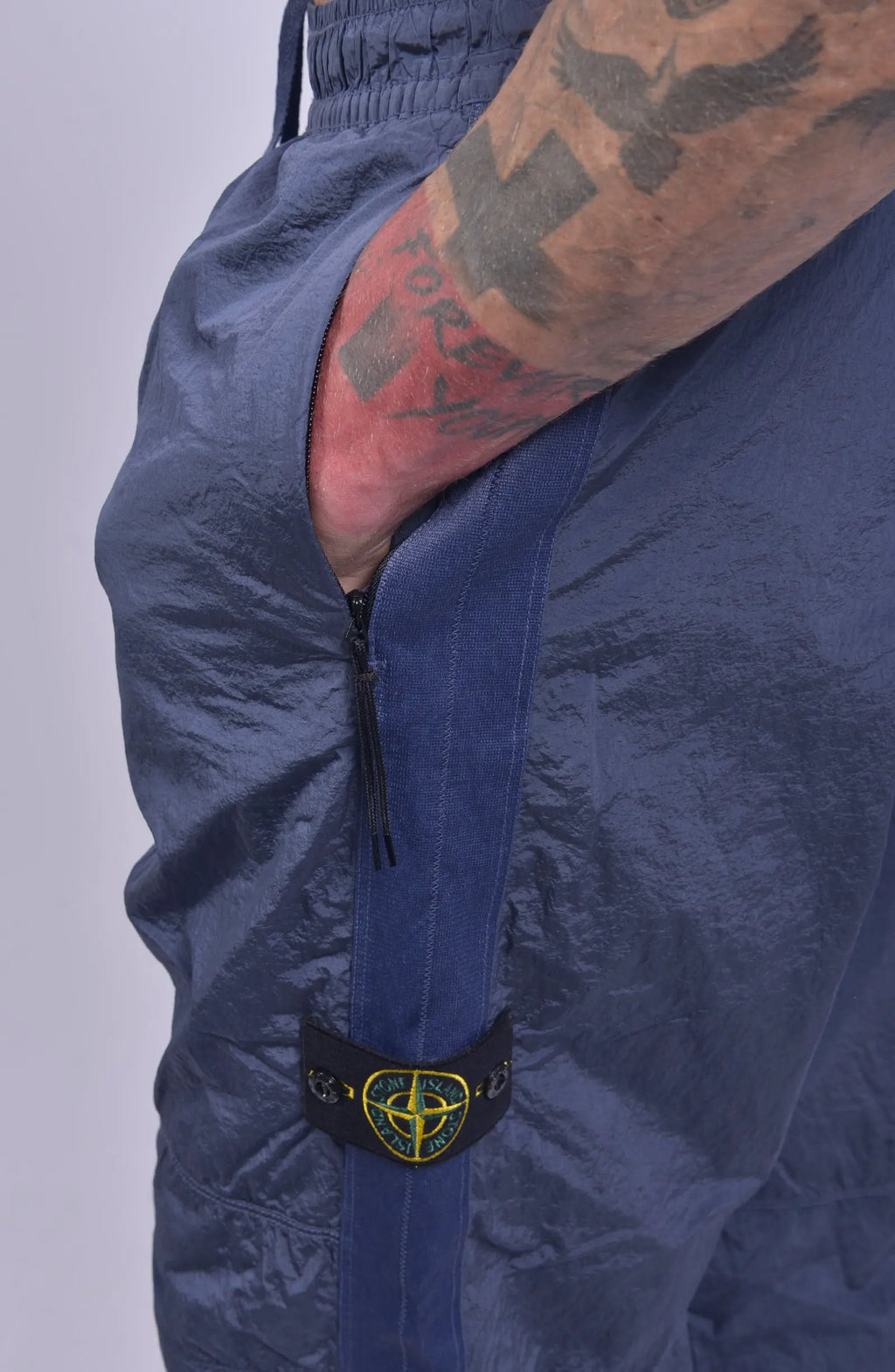 Stone Island, Mens Pants, Pastel Blue V0046, Loose Fit Joggers, Elasticated waistband, Drawstrings, Side Pockets, Compass Badge, Elasticated Ankles, YKK Zippers, Side Pocket Close-up. 
