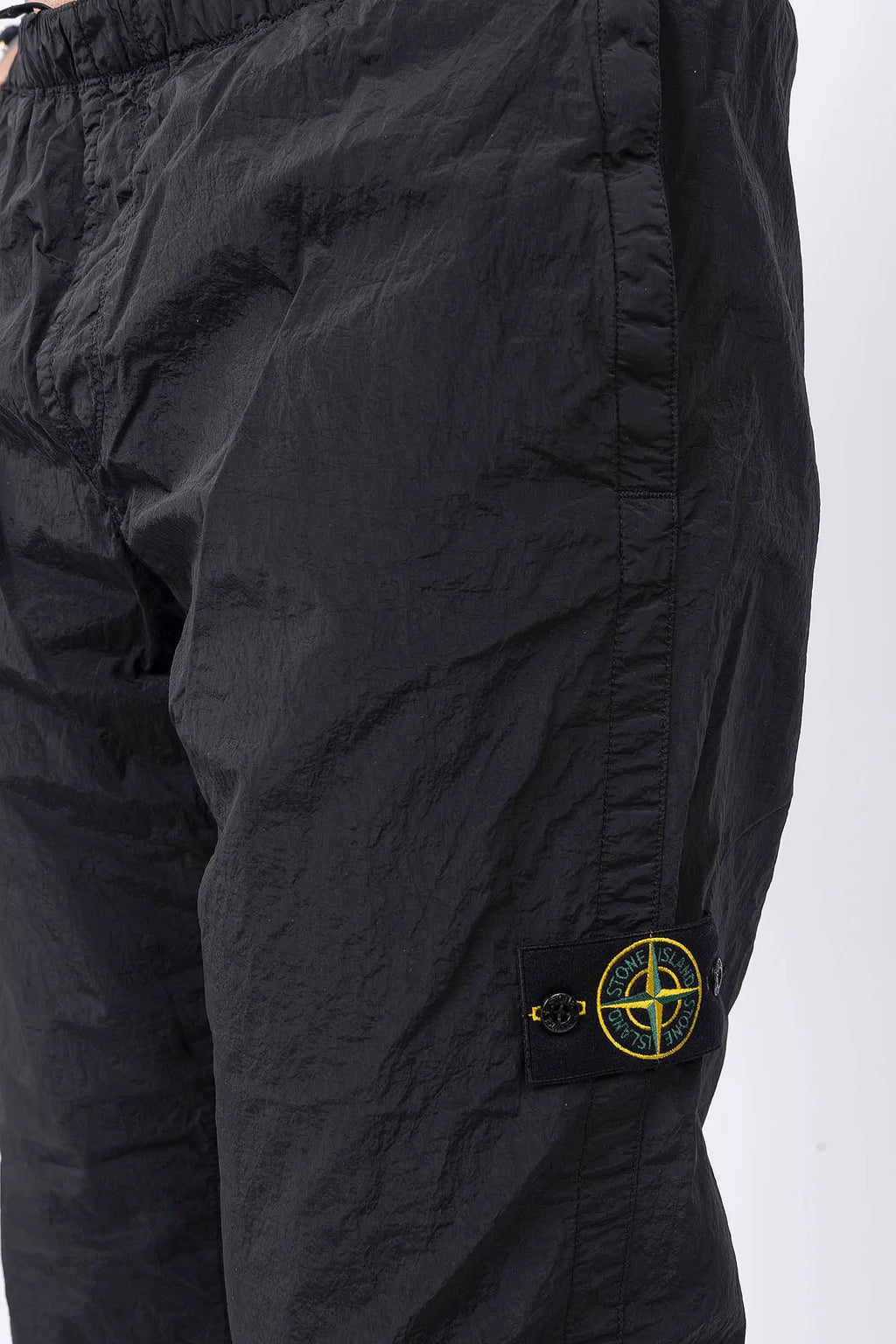 Stone Island, Mens Pants, Mens Trousers, Black V0029, Regular Fit, Tapered Legs, Side Pockets, Vertical Welt Pockets, Back Pockets, Elaticated Waistband, Drawstring Waist, Compass Badge, Logo-patch, Signature Side Badge, Pocket and Badge Close-up. 