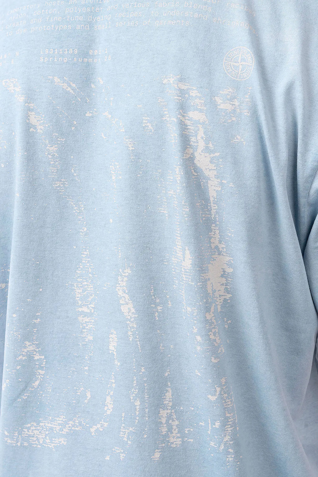 Stone Island, Mens T-Shirt, Dust Blue V004A, Uneven Cold Dyed, Front and Back Print, Wide Fit, Ribbed Hem, Ribbed Cuffs, Ribbed Neck, 100% Cotton, Organic Cotton, White Print, Graphic Back Print with Compass Logo, Logo-patch, Crew Neck, Round Neckline, Back Graphic Print Close-up. 