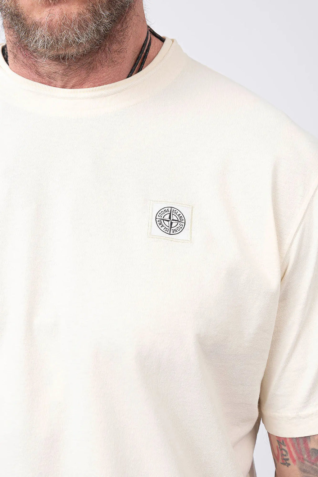 Stone Island, Mens T-Shirt, Ivory V0193, Off-White, White, Garment Dyed, Worn Effect, Short Sleeves, Elastic Ribbing, Organic Cotton, Wide Fit, Raw-cut Neck, Crewneck, Round Neck, Compass Badge, Logo-patch, Chest Compass Patch, Compass Patch Close-up. 