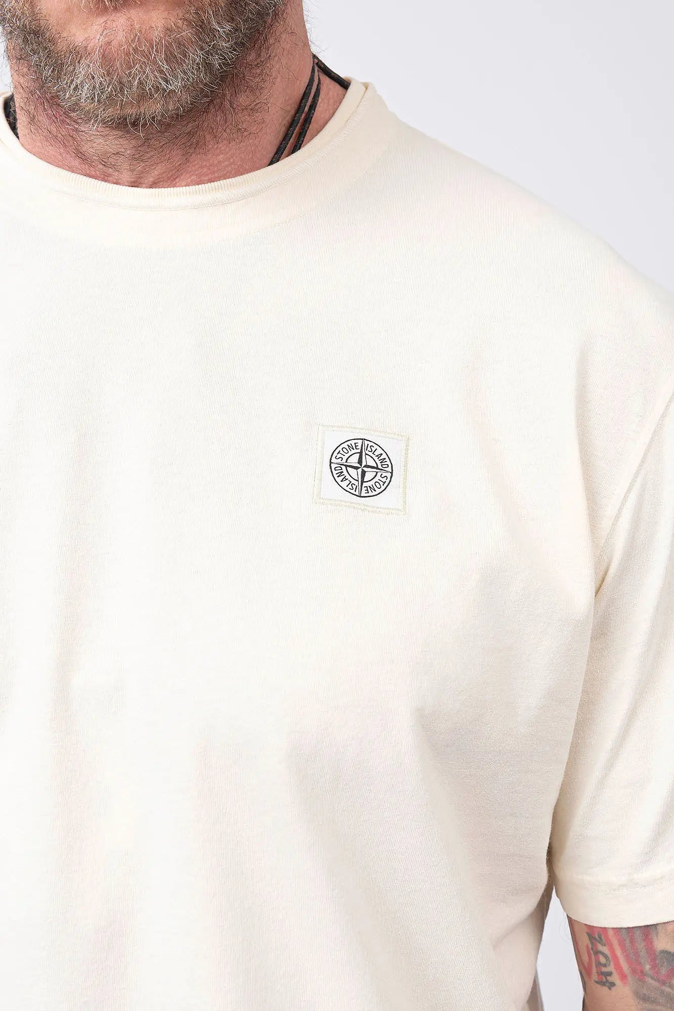 Stone Island, Mens T-Shirt, Ivory V0193, Off-White, White, Garment Dyed, Worn Effect, Short Sleeves, Elastic Ribbing, Organic Cotton, Wide Fit, Raw-cut Neck, Crewneck, Round Neck, Compass Badge, Logo-patch, Chest Compass Patch, Compass Patch Close-up. 