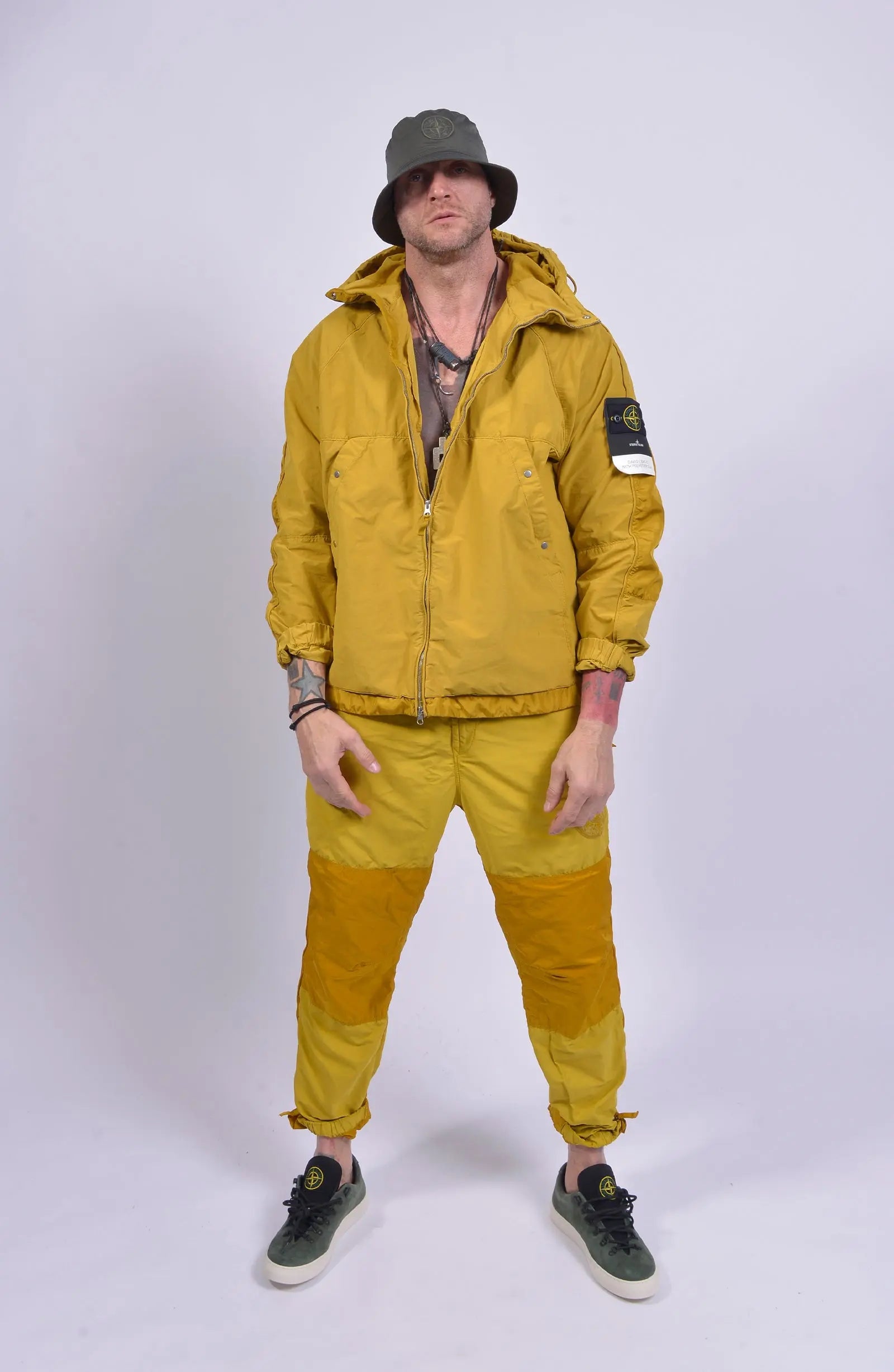 Stone Island, Mens Pants, Yellow, Orange, Elasticated Waistband, Elasticated Ankles, YKK Zippers, Zipper Pockets, Side Pockets, Compass Embroidery, Yellow Jacket, Compass Badge, S.I. Sneakers, Bucket hat, Tattoos, Complete Fit Shot.